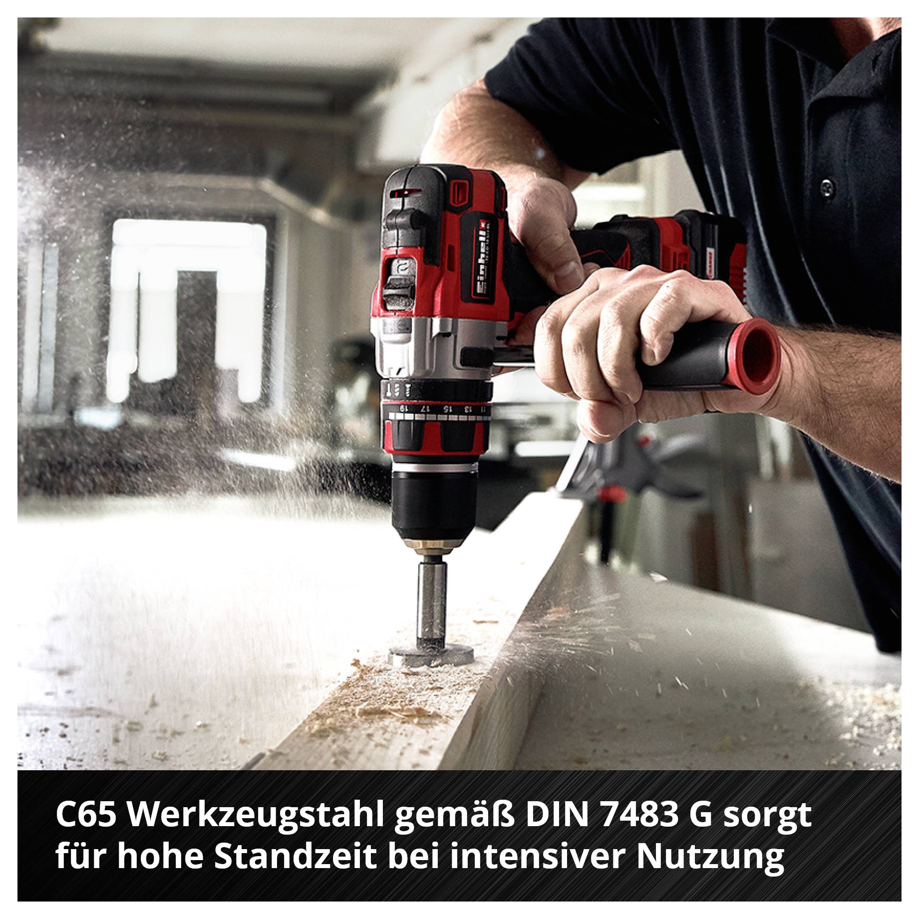 Handwerker bohrt mit einem roten Akkuschrauber in Metall; Staub fliegt, unten steht: 'C65 Werkzeugstahl gemäß DIN 7483 G sorgt für hohe Standzeit bei intensiver Nutzung'.