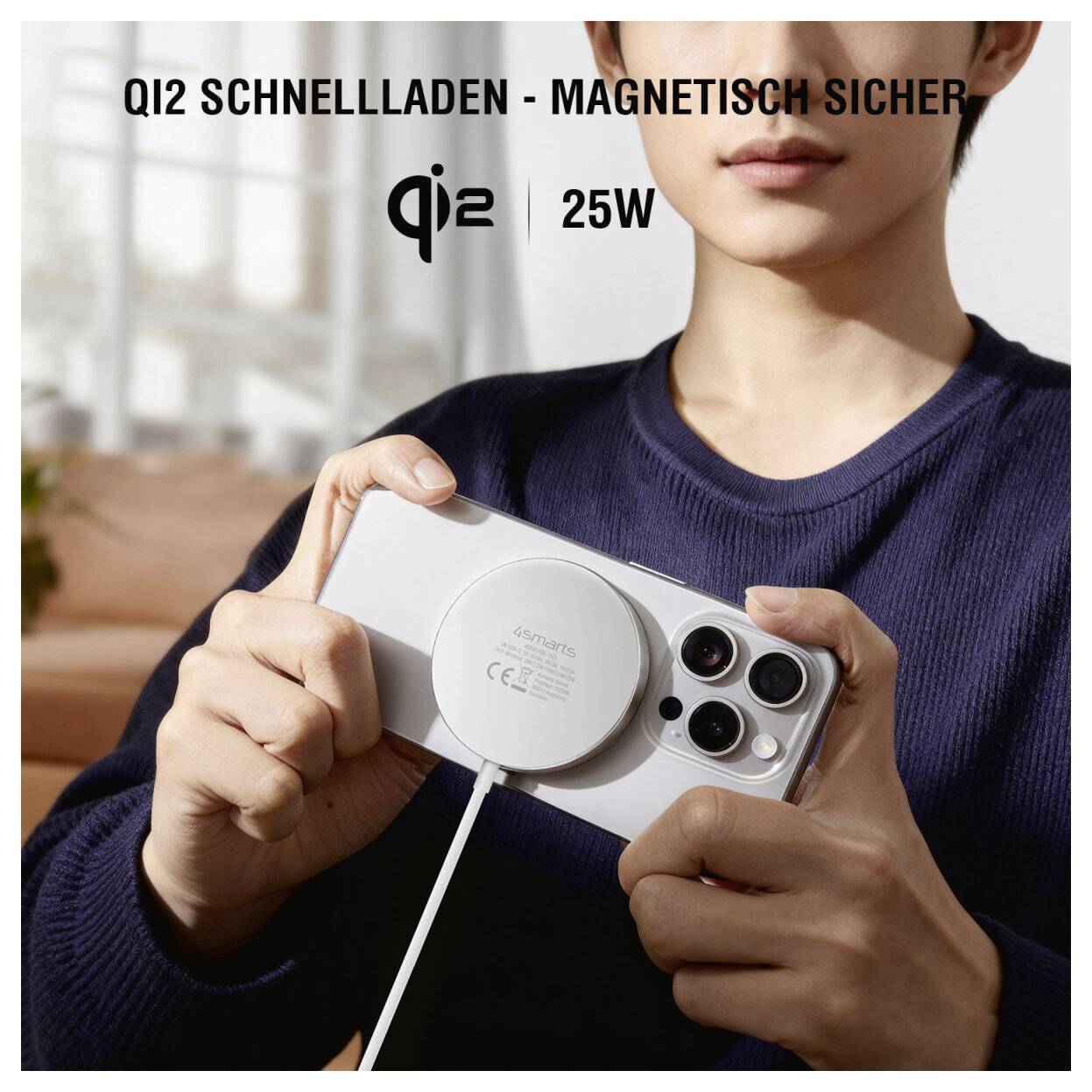Person hält ein Smartphone mit einem magnetischen kabellosen Ladegerät; Text besagt „QI2 SCHNELLLADEN - MAGNETISCH SICHER