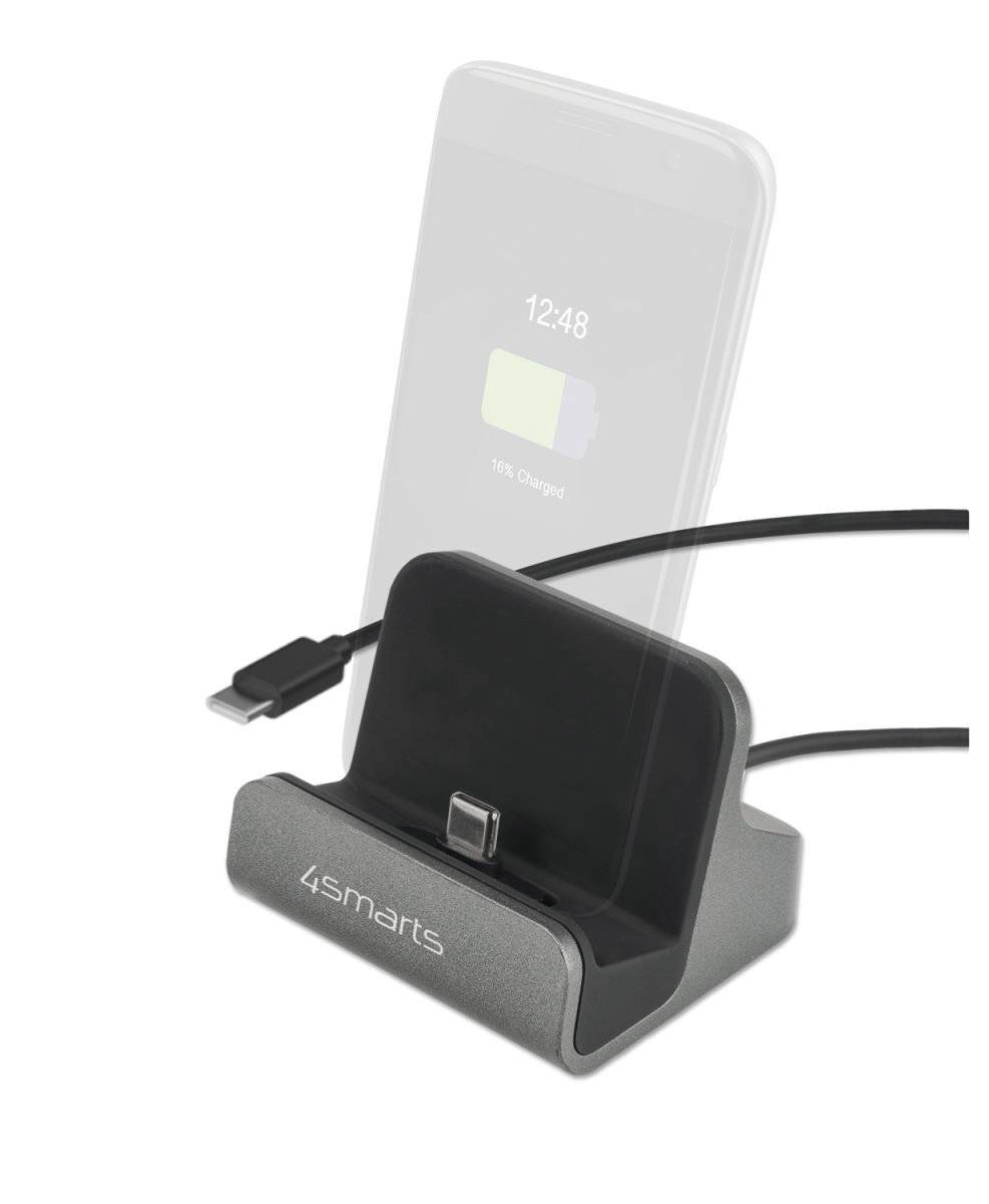Schwarze 4smarts Ladestation mit USB-C-Kabel, die ein Smartphone aufrecht in der Halterung auflädt, wobei der Batteriestatus auf dem Bildschirm angezeigt wird.