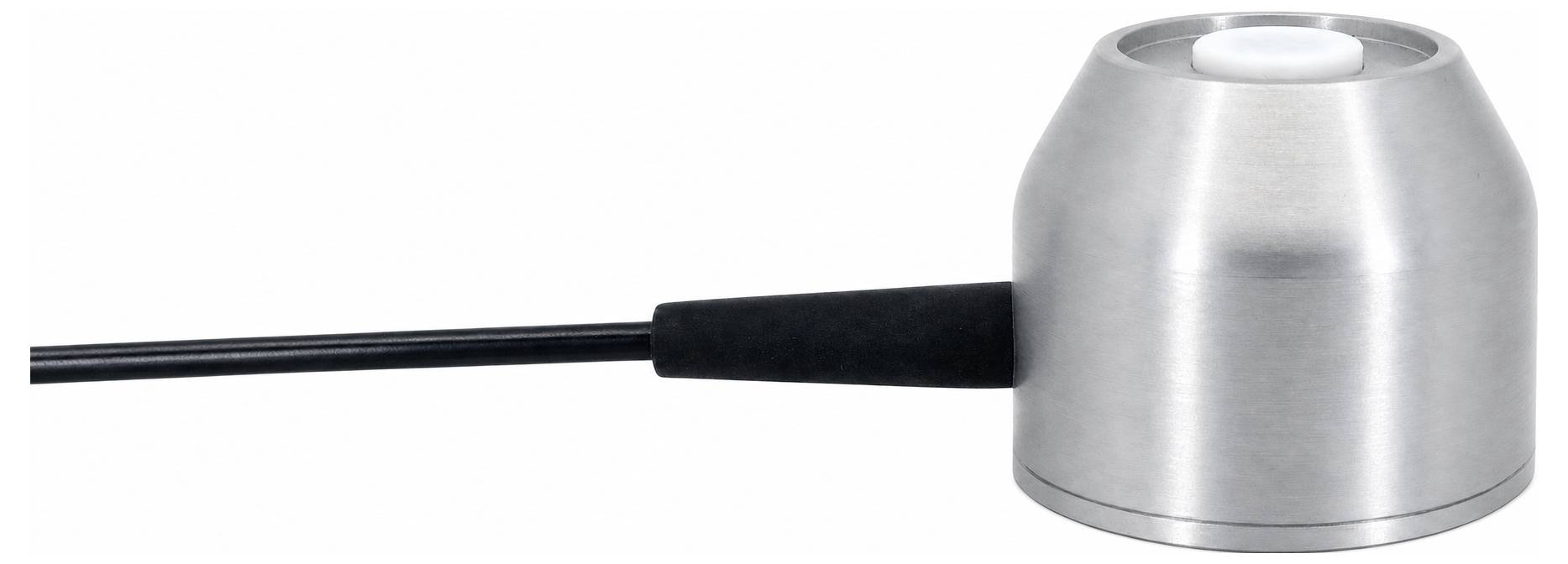 Ein kleines metallisches zylindrisches Gerät mit einer zentralen Öffnung oben und einem schwarzen Kabel, das von der Seite herausragt, vor weißem Hintergrund gezeigt.
