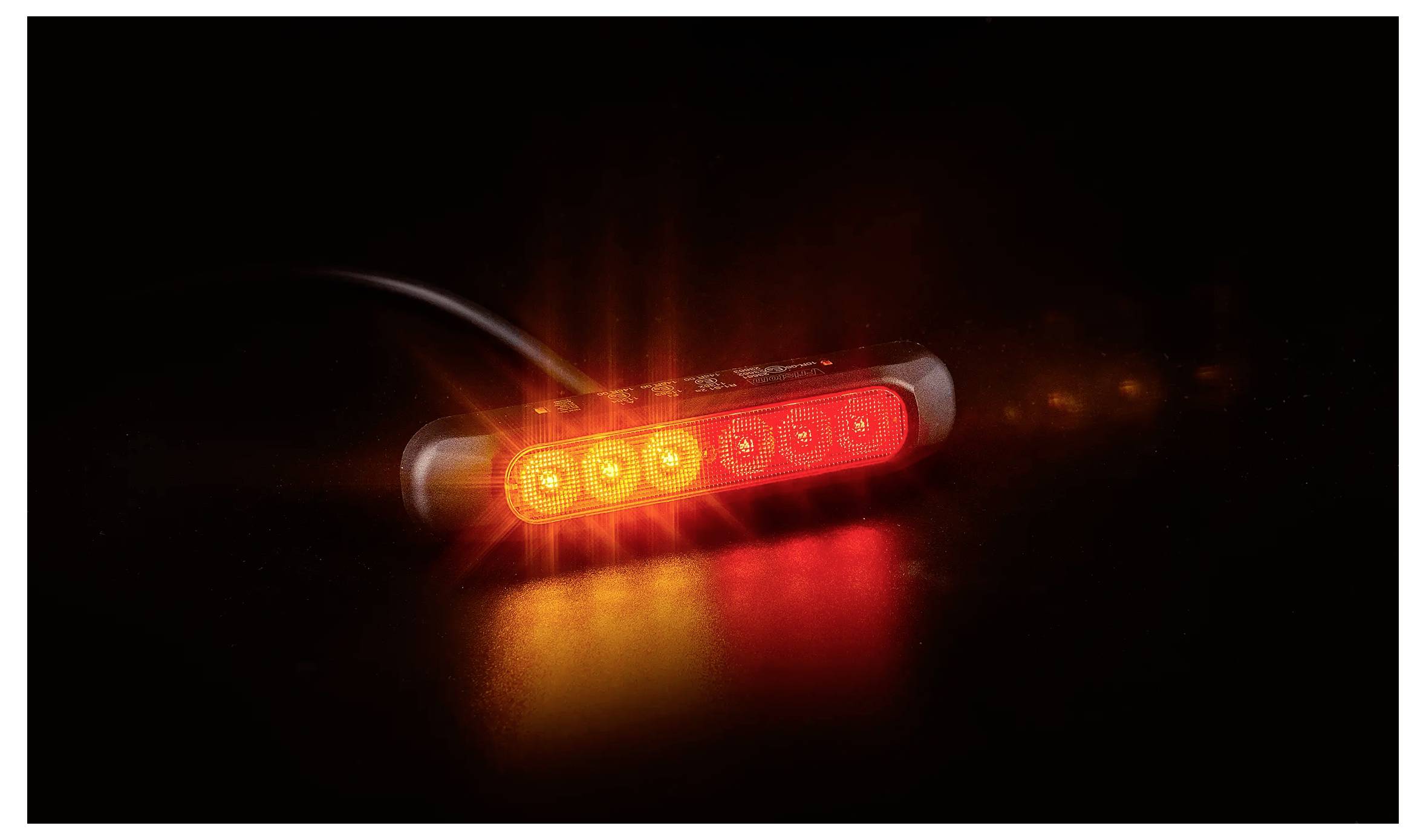 Leuchtende rote LED-Lichtleiste auf dunklem Hintergrund mit einer Spiegelung darunter.