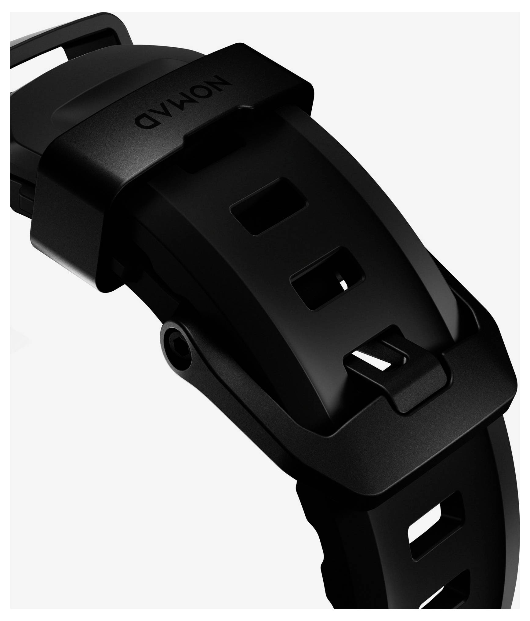 Nahaufnahme eines schwarzen Uhrenarmbands und einer Schnalle mit dem Markennamen "NOMAD" auf der Schließe.