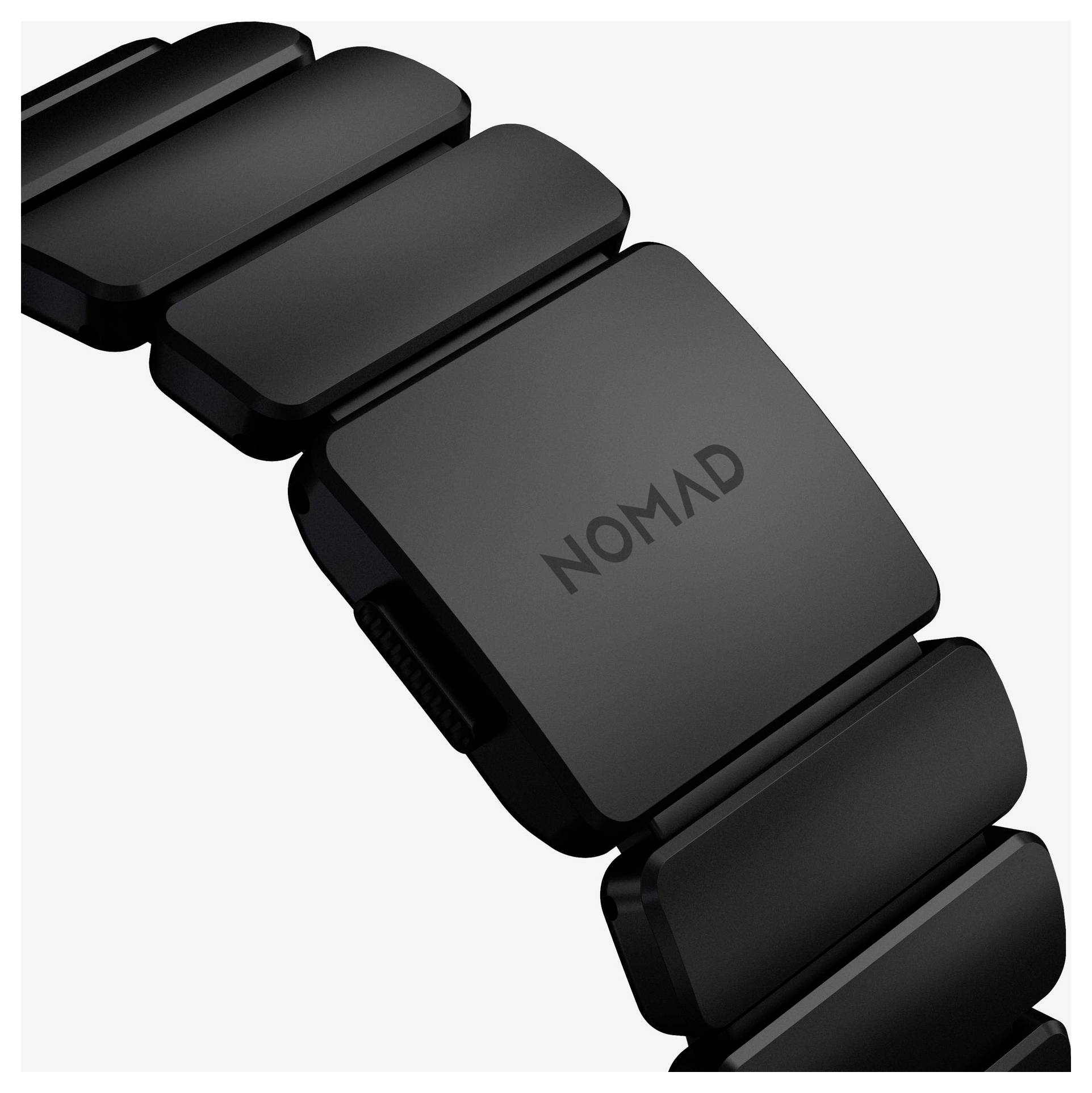 Nahaufnahme eines schwarzen segmentierten Smartwatch-Armbands mit matter Schließe mit der Beschriftung „NOMAD" auf weißem Hintergrund.