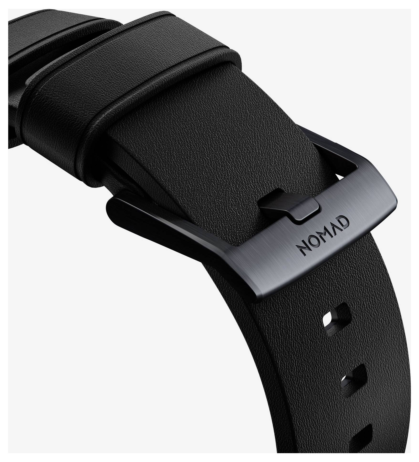 Schwarzes Lederarmband mit gebürstetem Metallverschluss, auf dem "NOMAD" graviert ist, auf weißem Hintergrund.