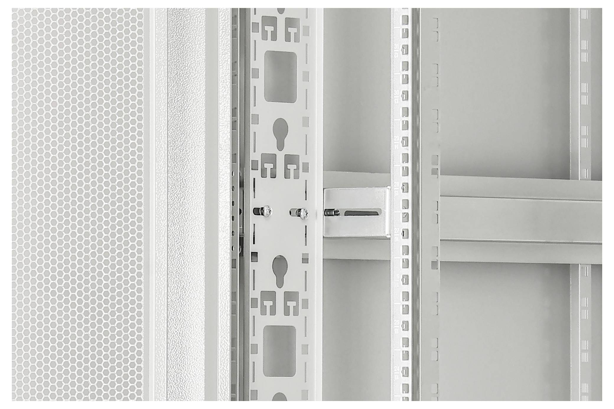 Nahaufnahme eines weißen Metallregals oder Schranks mit perforierten Schienen und Paneelen in einem sauberen, minimalistischen Innenraum.