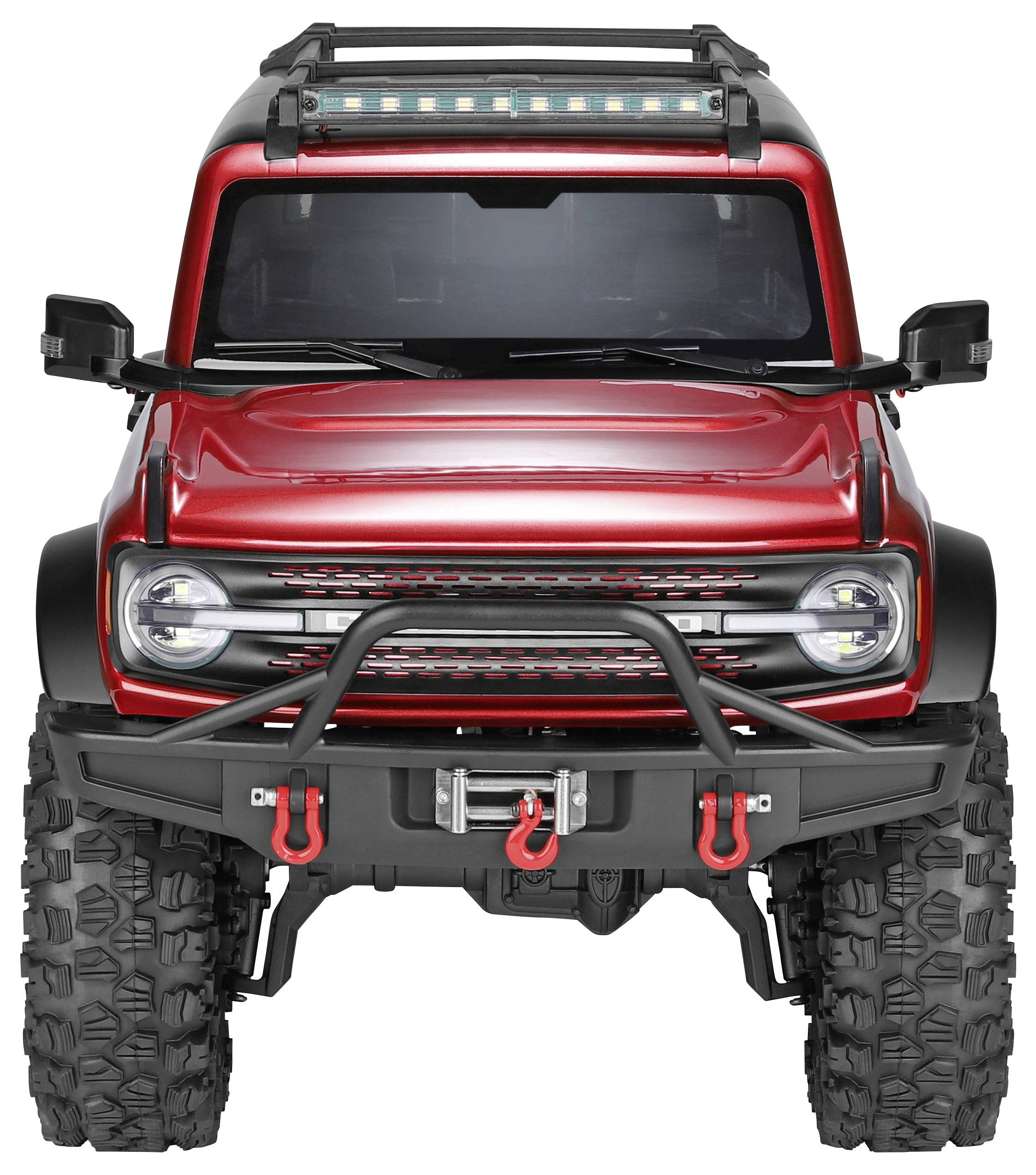 Rotes Gelände-SUV mit übergroßen Reifen, vorderer Stoßstangenschutz, Winde, Dachträger und Lichtleiste, von vorne auf weißem Hintergrund dargestellt.