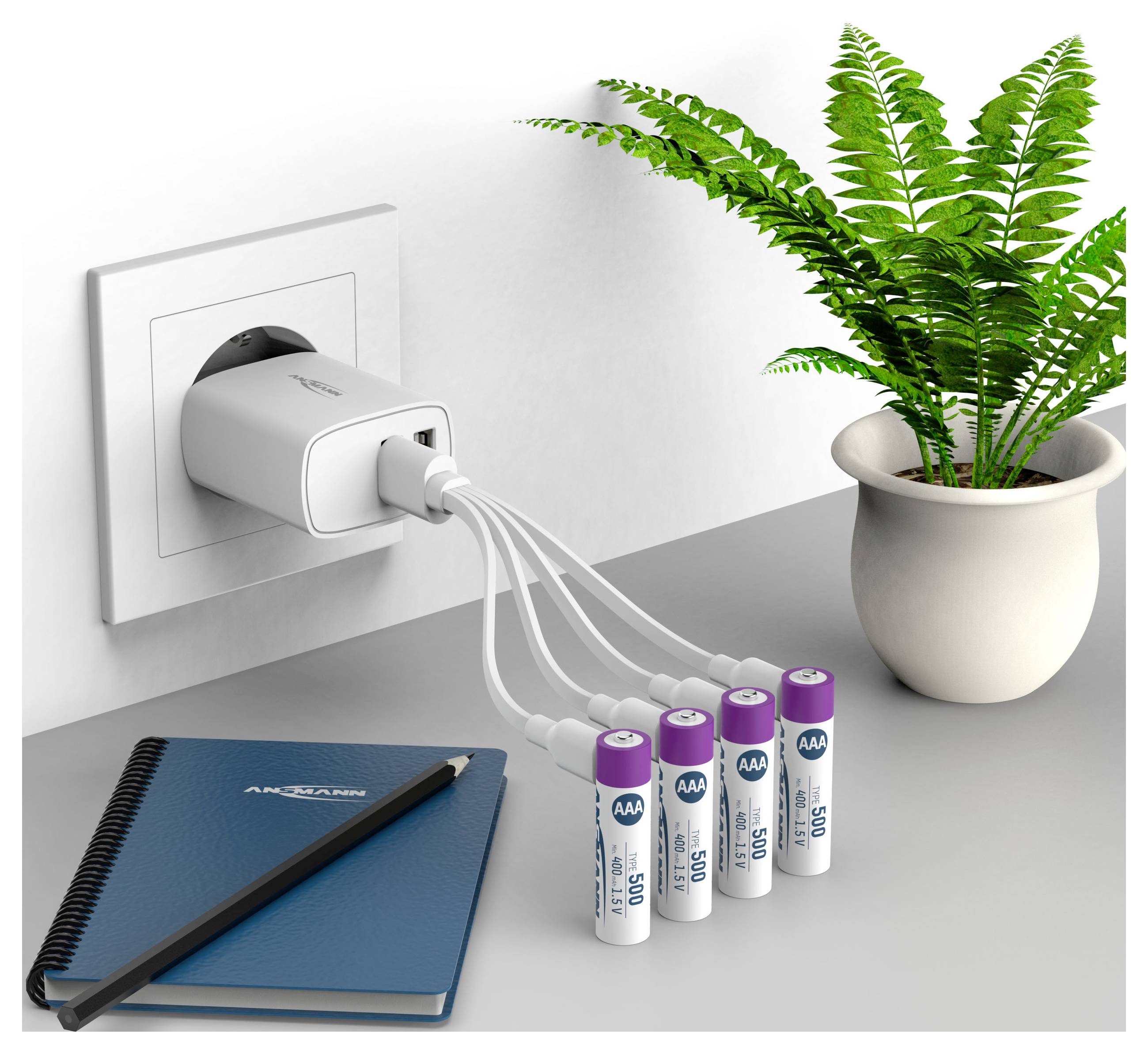 USB-Ladegerät neben einer Topfpflanze, das vier AA-Batterien mit Kabeln auf einem Schreibtisch mit einem Notizbuch und Bleistift versorgt.