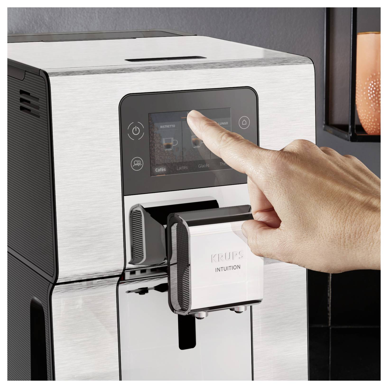 Hand drückt einen Touchscreen an einer Krups-Kaffeemaschine, um ein Getränk auszuwählen.