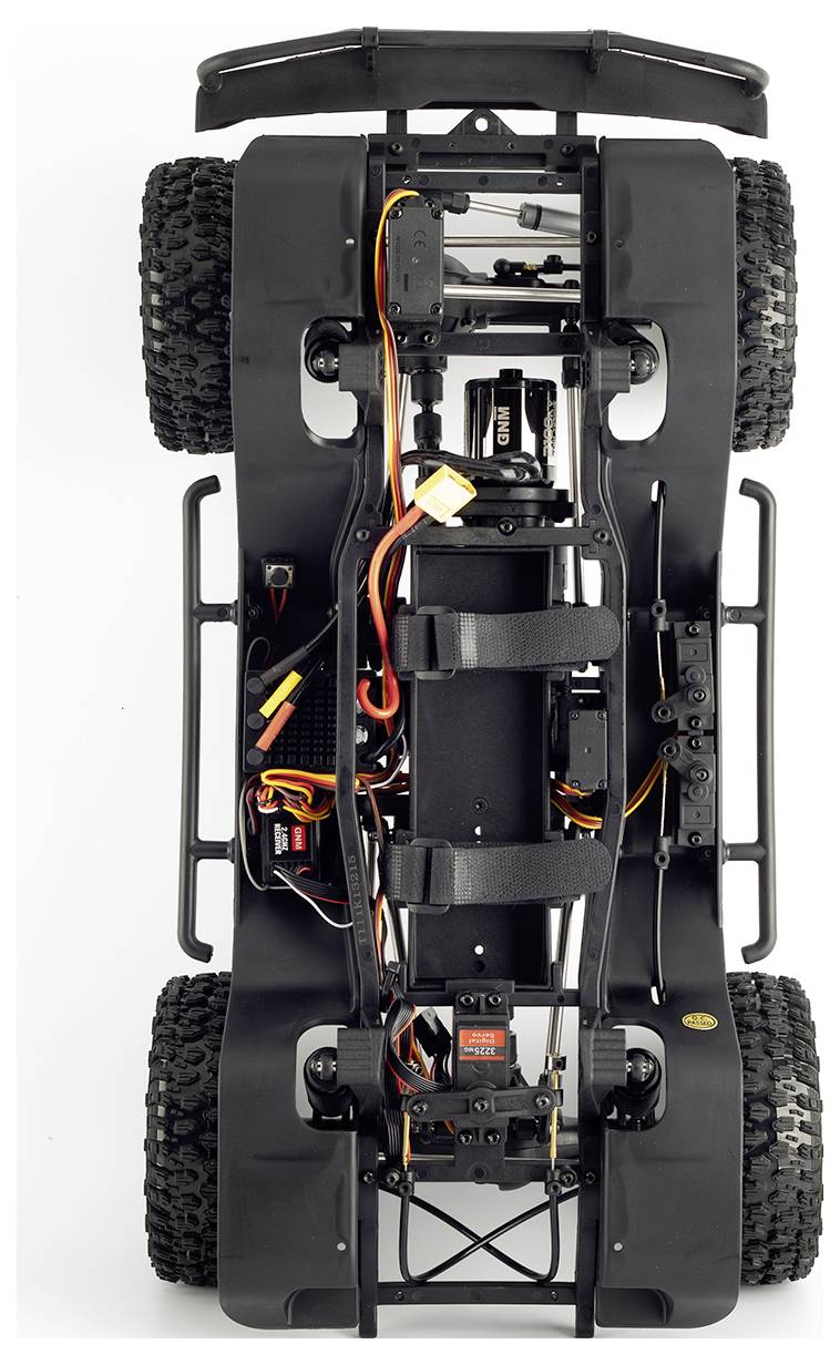 Unteransicht eines ferngesteuerten Geländefahrzeug-Chassis mit Aufhängung, Verkabelung, Batterie und vier großen Stollenreifen.