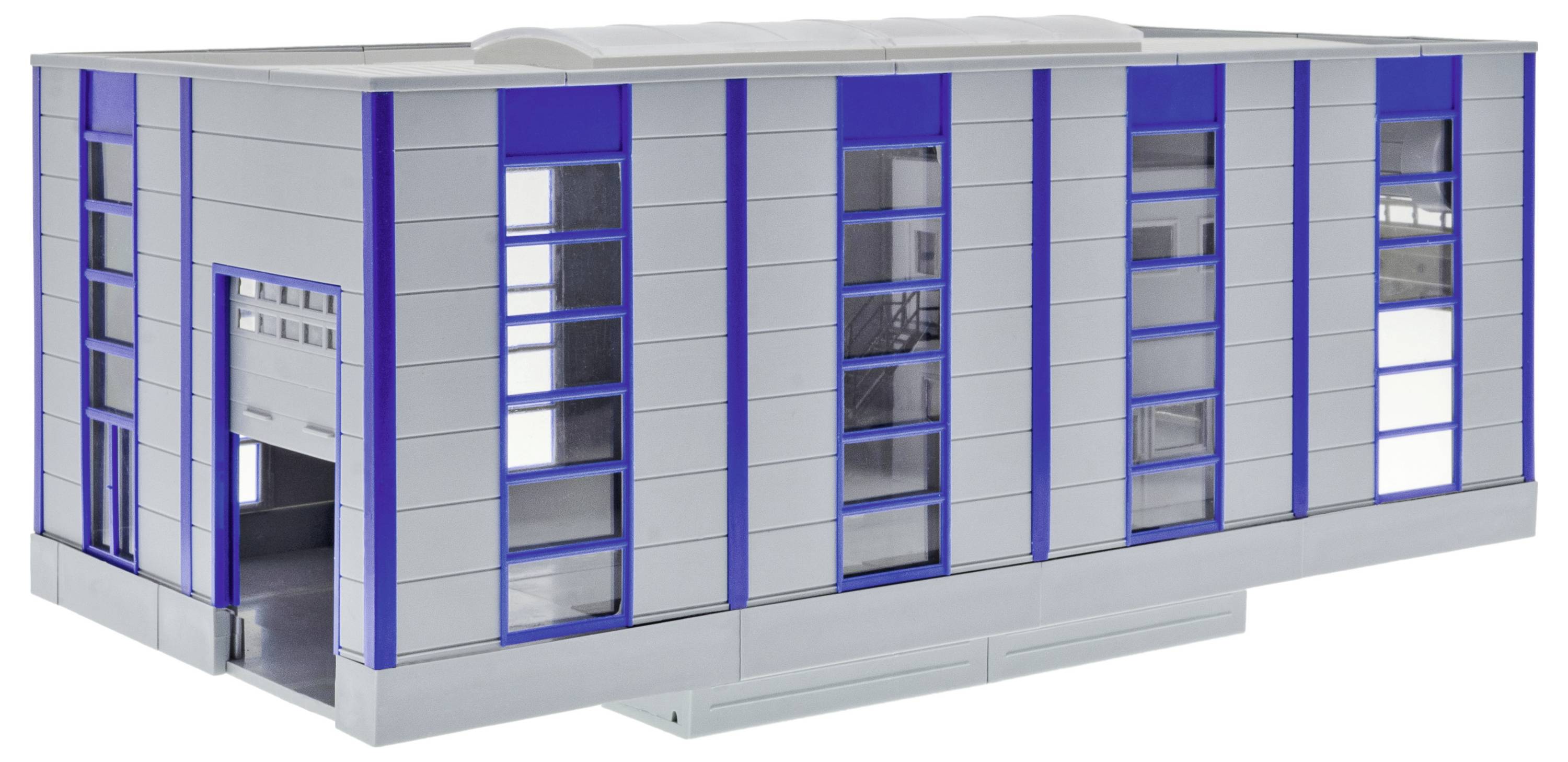 Außenseite eines modularen Industriegebäudes mit blauen vertikalen Akzenten, hohen schmalen Fenstern und einer großen offenen Ladetoranlage.