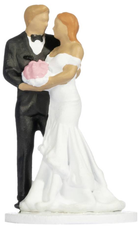 Hochzeitstorte-Figur eines sich umarmenden Brautpaares, die Braut in einem weißen Kleid mit rosa Blumen in der Hand, der Bräutigam in einem schwarzen Smoking.