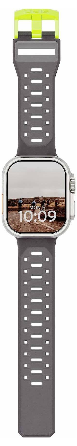 Smartwatch mit grauem perforiertem Sportarmband und quadratischem Zifferblatt, das 10:09 über einem Stadtlandschaftsfoto anzeigt.