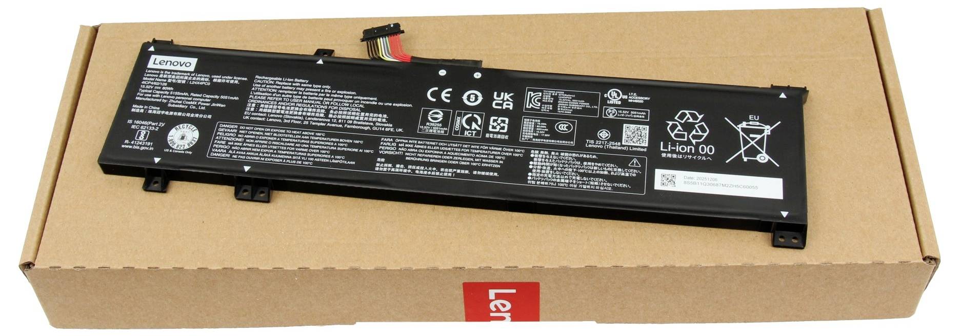 Schwarze Lenovo-Laptop-Akku-Pack auf einem Kartonkarton liegend, wobei Etiketten, Sicherheitszeichen und Anschlüsse sichtbar sind.
