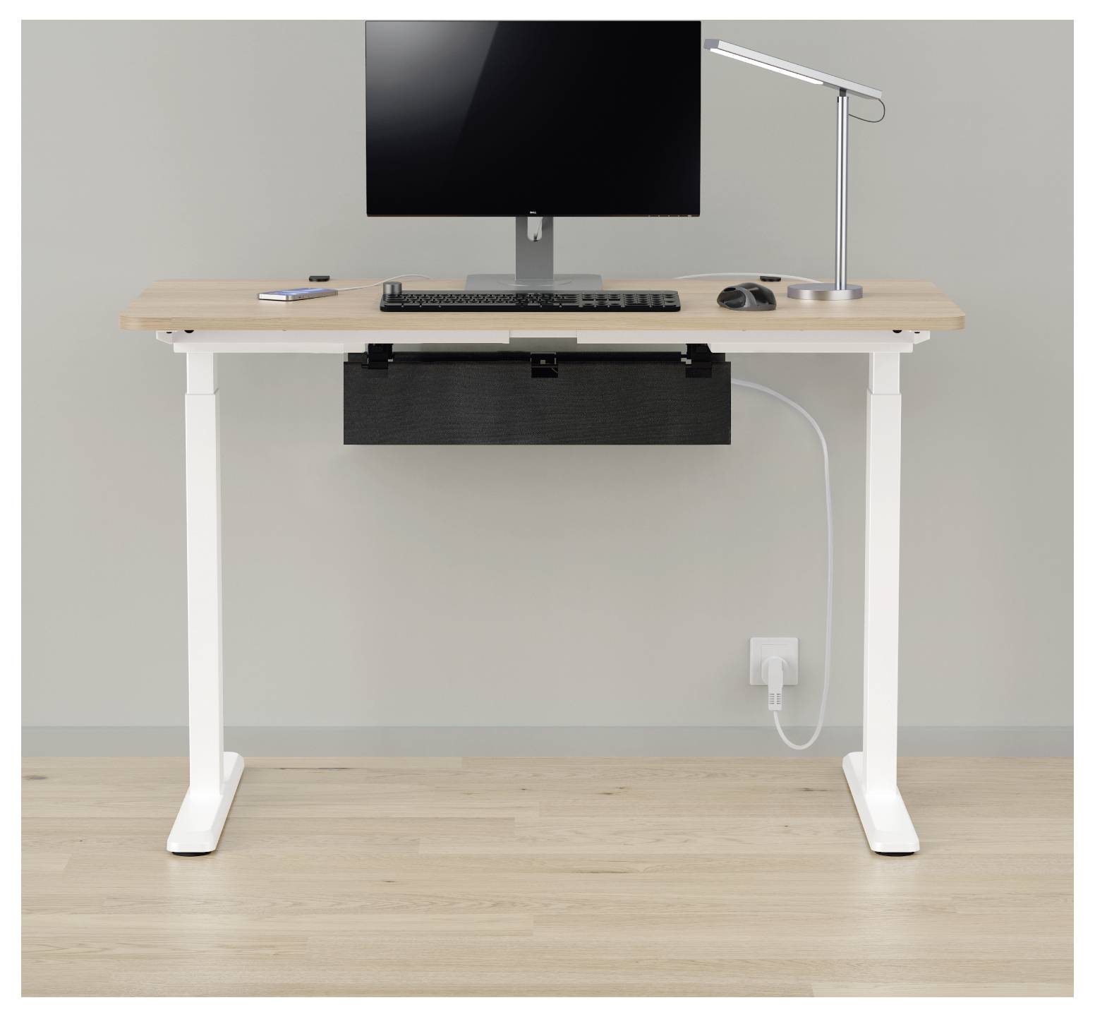 Stehschreitisch-Setup mit Monitor, Tastatur, Maus, Lampe und Kabelmanagement-Schublade an einer schlichten Wand.