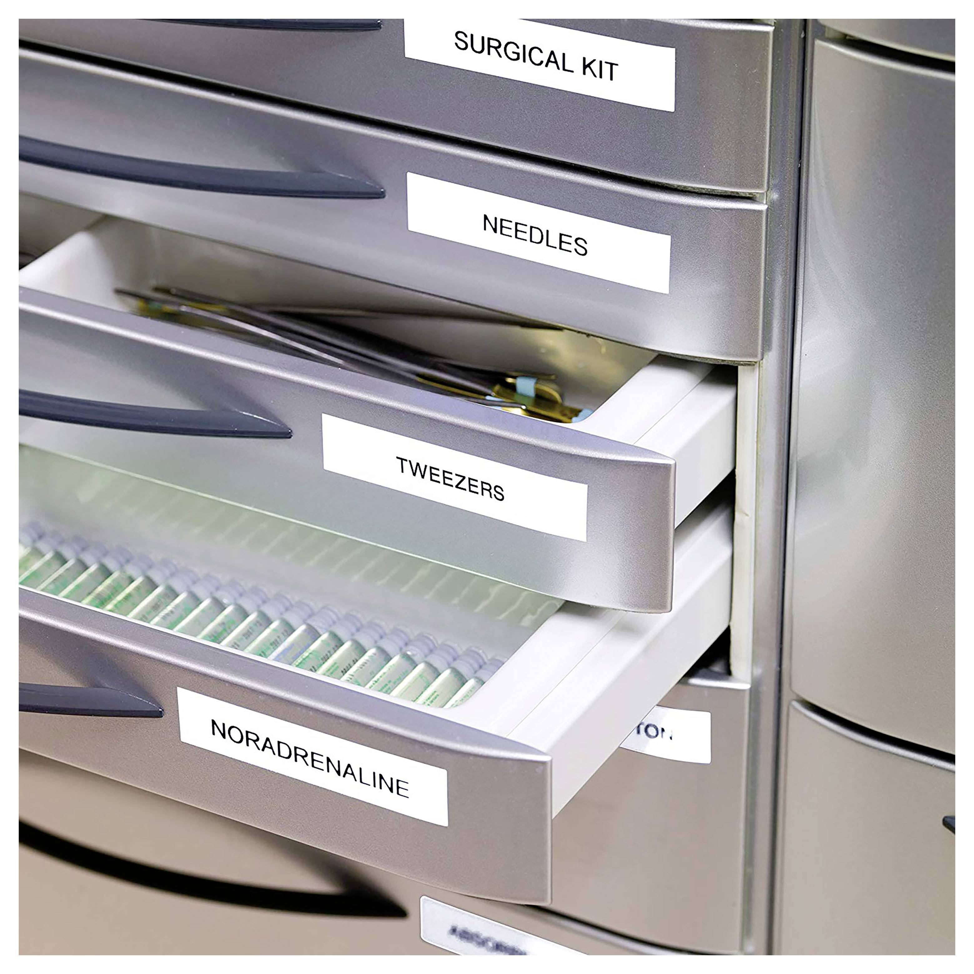 Öffnen Sie den medizinischen Vorratsbehälter mit beschrifteten Schubladen für 'CHIRURGISCHES SET', 'NADELN', 'PINZETTEN' und 'NORADRENALIN'.