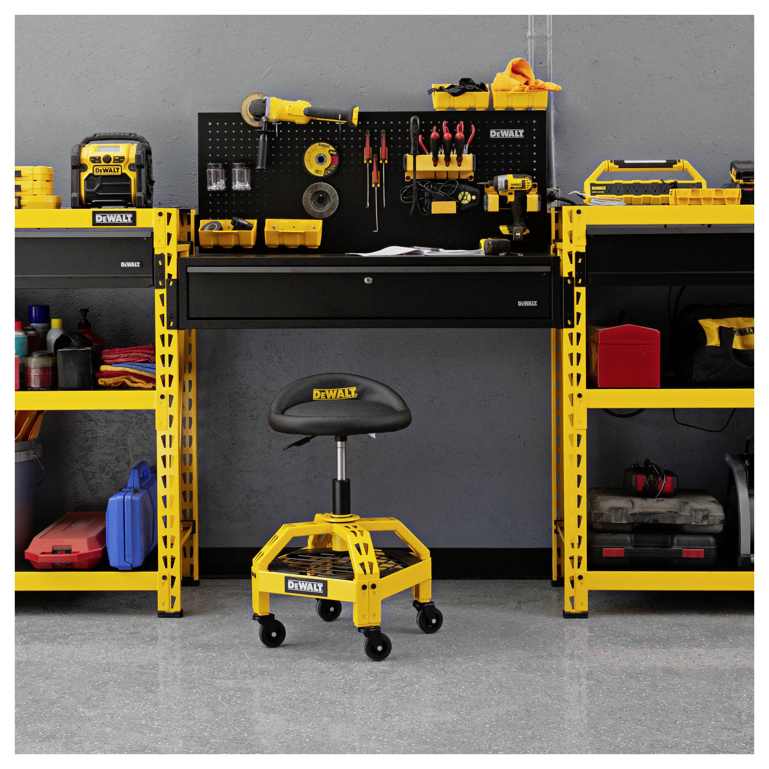 Gelbe DEWALT-Werkzeuglagerung mit einer wandmontierten Lochwand, Regalen, einer Werkbank und einem fahrbaren Werkstattschemel in einer Garage.