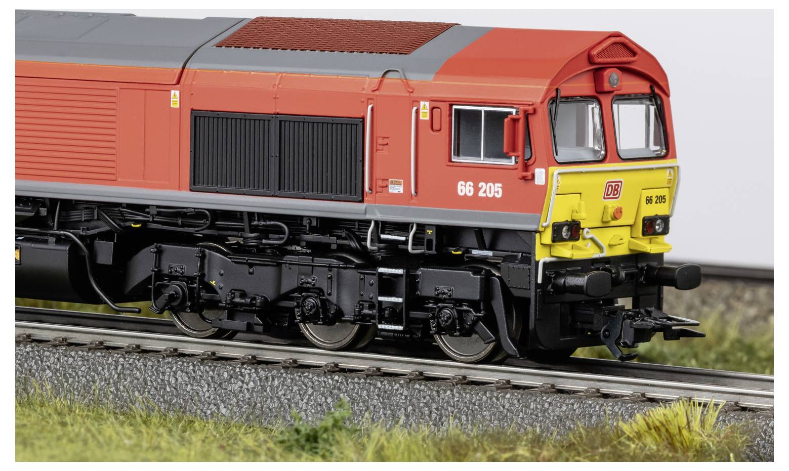 Rote und gelbe Diesellokomotive auf Eisenbahngleisen, Seitenansicht im Freien gezeigt.