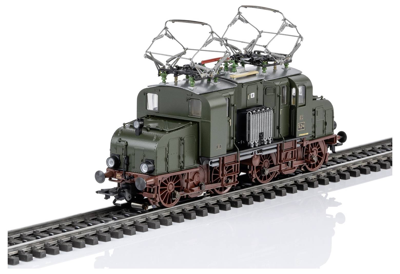 Grüne Modell-Elektrolokomotive auf Eisenbahngleisen, gezeigt in Dreiviertelansicht mit angehobenen Stromabnehmern und detaillierten Rädern.