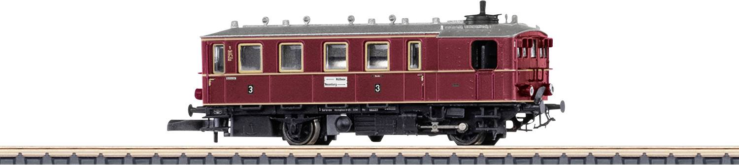 Seitenansicht eines kastanienbraunen Eisenbahnwagen-Modells auf Gleisen, mit sichtbaren Fenstern, Türen und Dachdetails vor einem einfachen weißen Hintergrund.