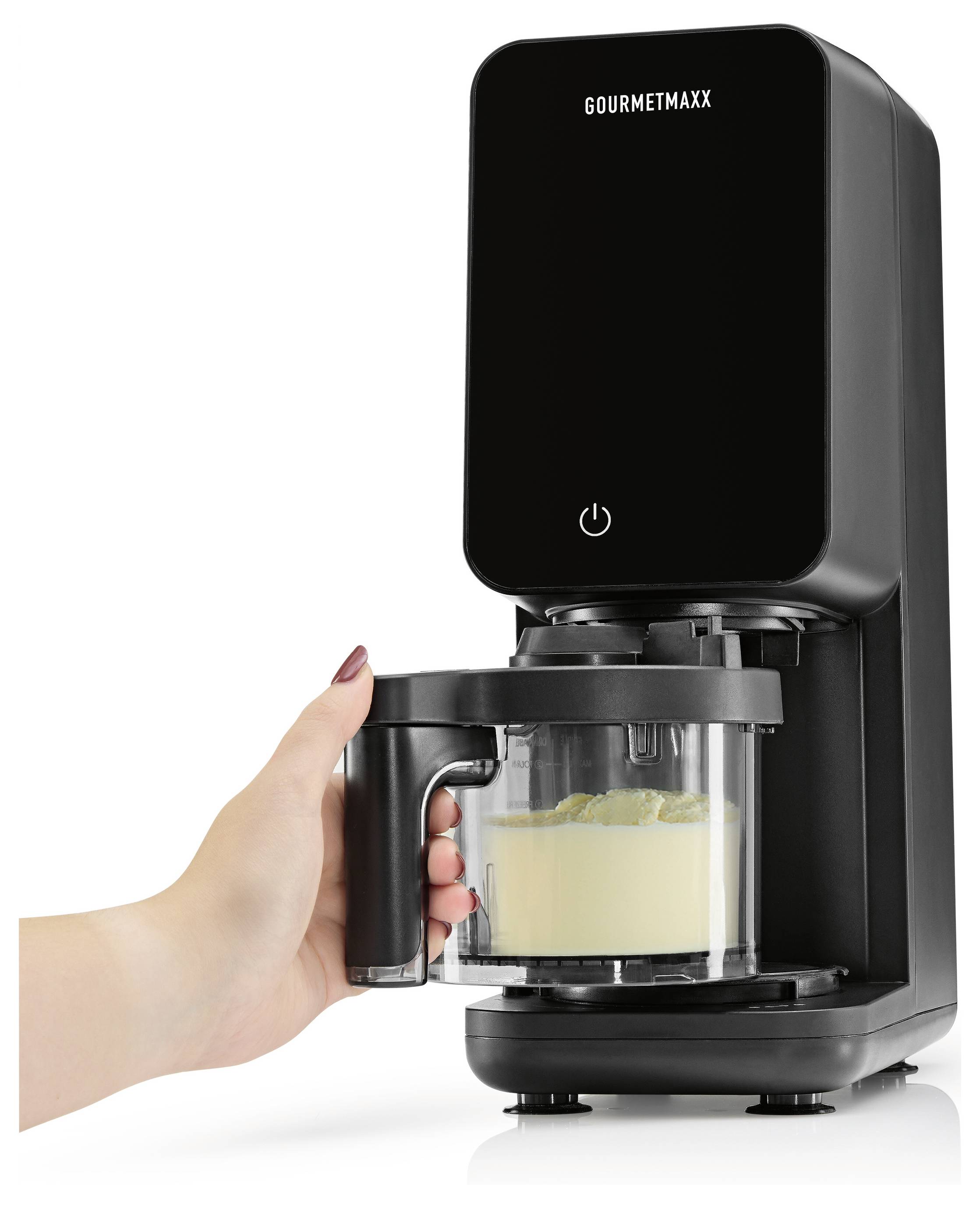 Eine Hand hält eine transparente Rührschüssel unter einer GOURMETMAXX Küchenmaschine mit schwarzem Gehäuse, wobei Teig in der Schüssel vermischt wird.