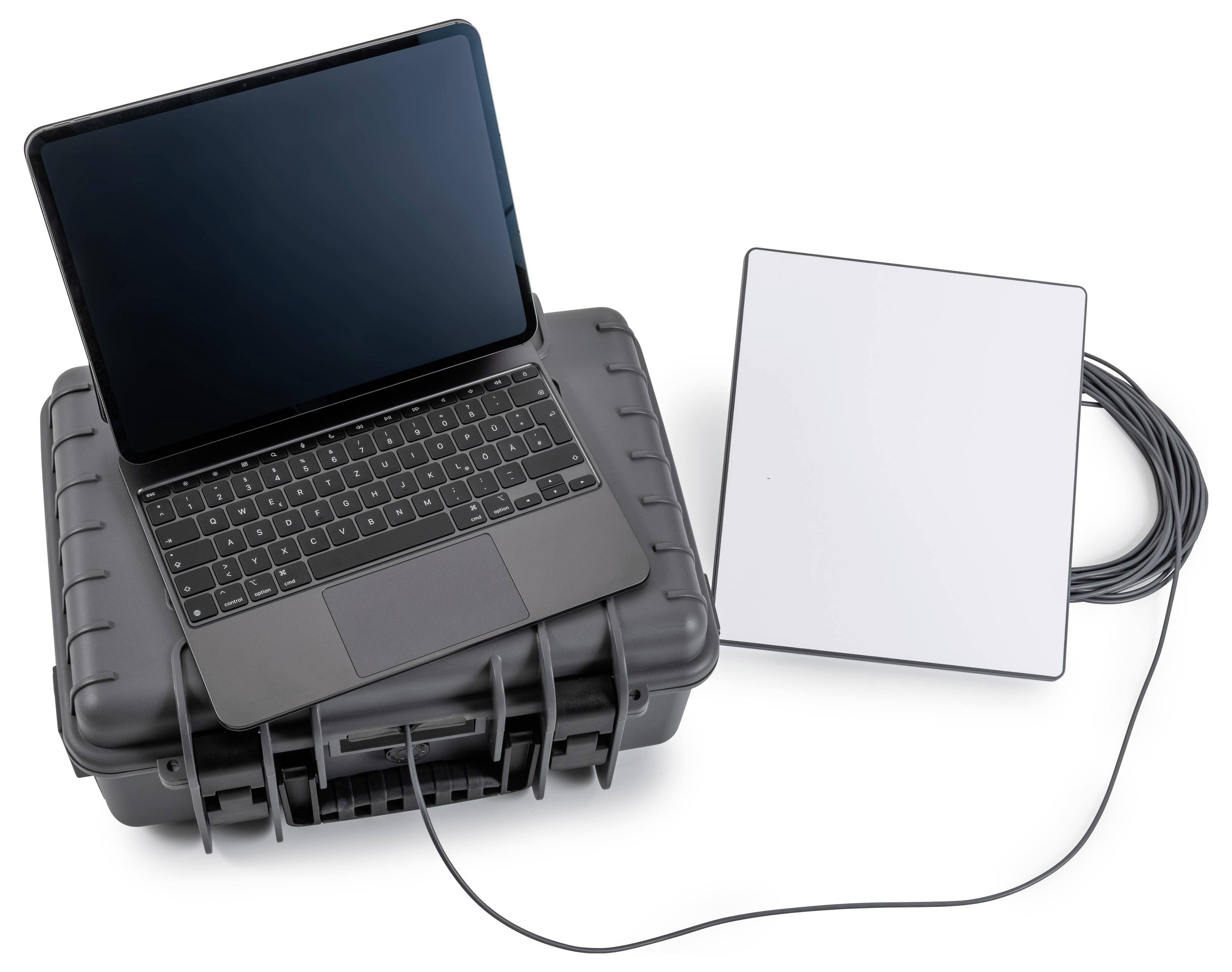 Ein Laptop sitzt in einem robusten Transportkoffer und ist durch ein Kabel mit einem weißen externen Gerät verbunden, wahrscheinlich einer tragbaren Antenne oder einem Sensor.