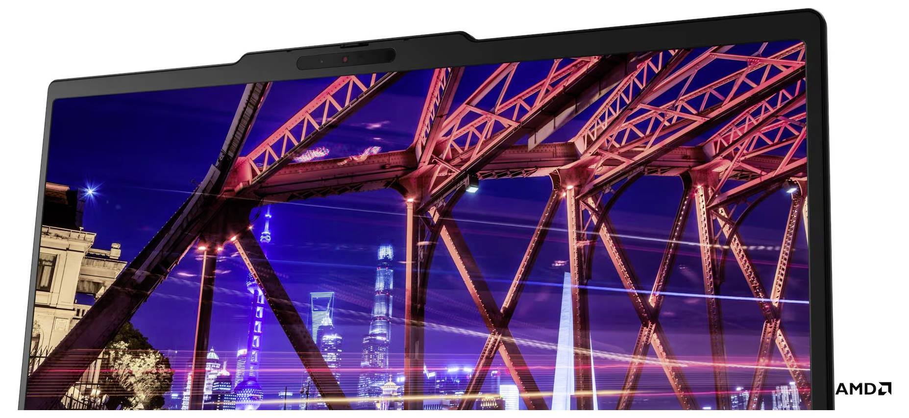 Ein Laptop zeigt eine lebendige Stadtbrücke nachts mit rot beleuchteten Stahlträgern; das AMD-Logo erscheint in der unteren rechten Ecke.