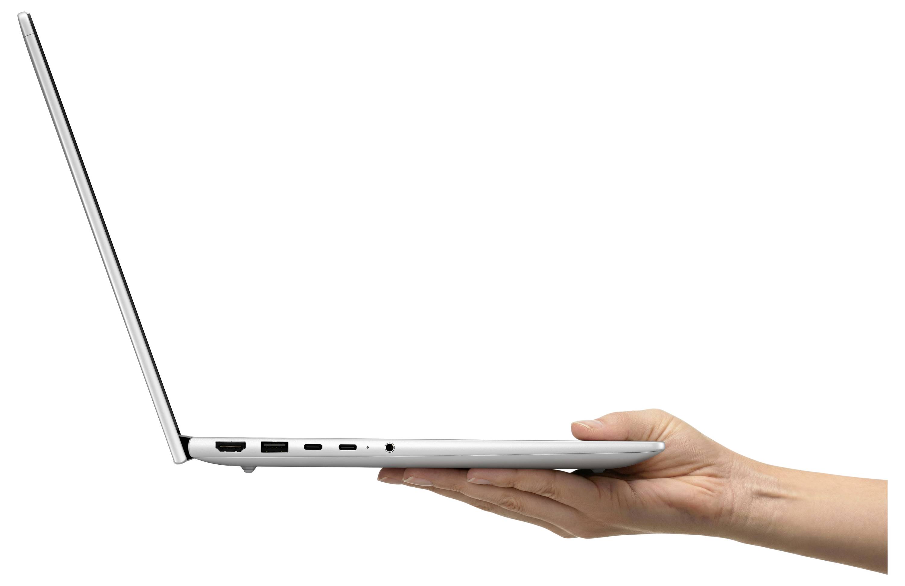 Eine Hand hält einen offenen silbernen Laptop in der Seitenansicht, die sein dünnes Profil vor einem weißen Hintergrund zeigt.