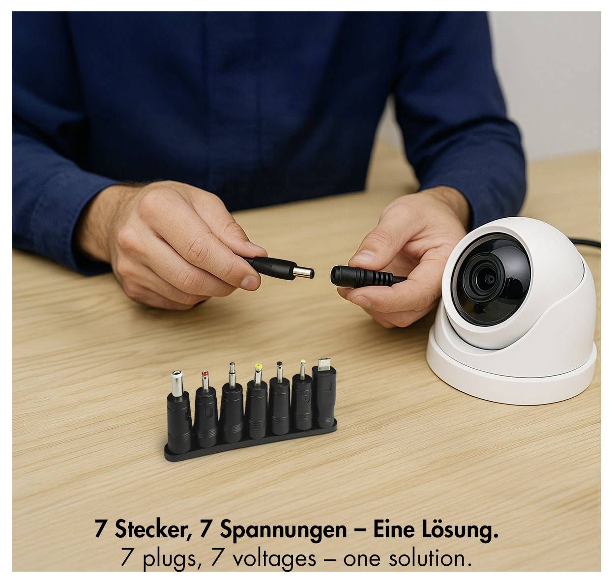 Person verbindet einen Stromstecker mit einer weißen Sicherheitskamera neben einer Reihe von 7 austauschbaren Steckerspitzen; Text sagt „7 Stecker, 7 Spannungen – eine Lösung.
