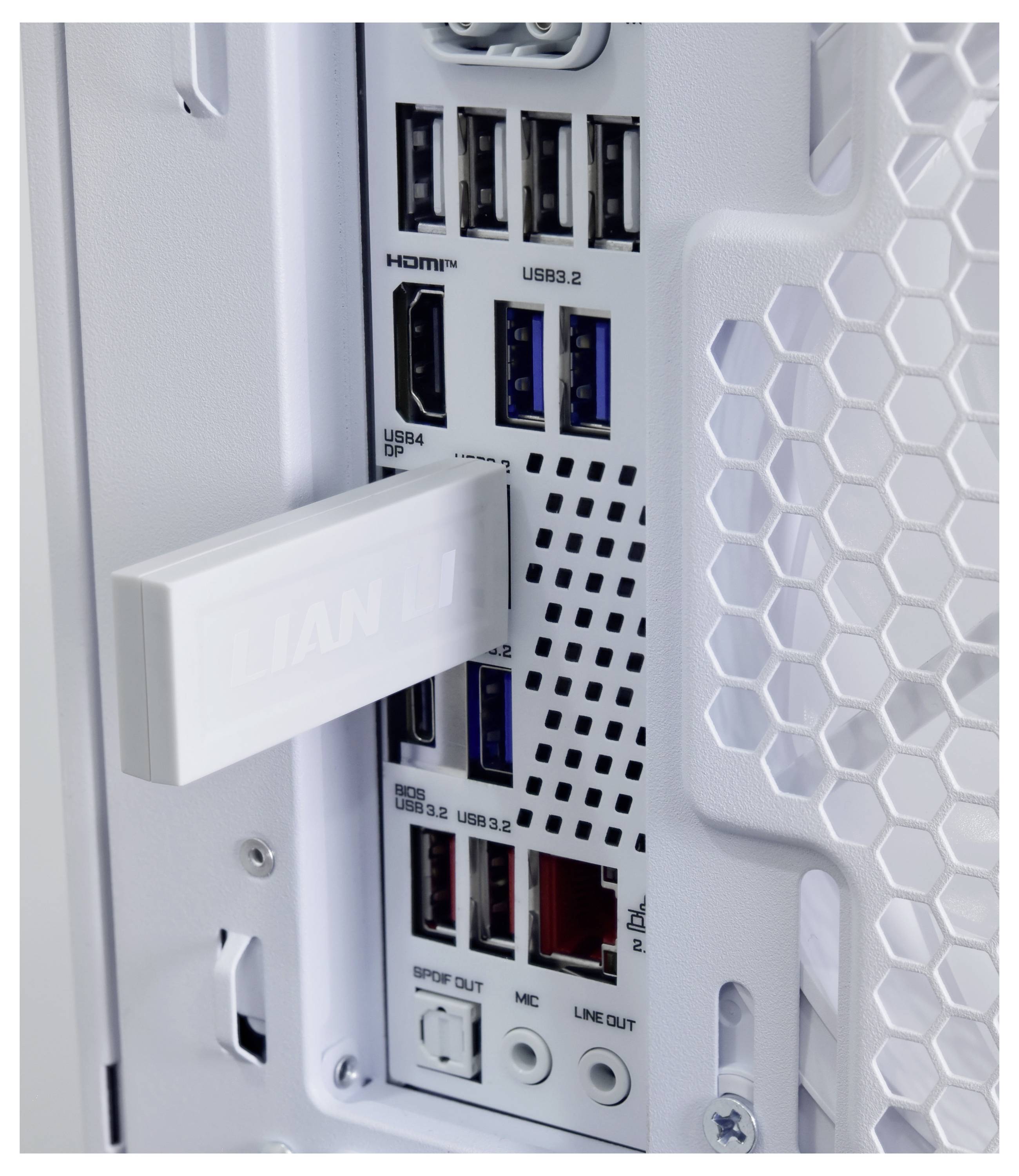 Nahaufnahme einer weißen PC-Tower-Rückseite mit I/O-Panel mit HDMI-, USB 3.2/USB 4-, Audio- und Netzwerkports, teilweise bedeckt durch eine weiße Halterung.
