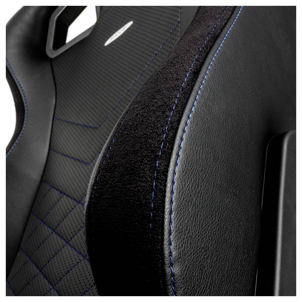 Nahaufnahme eines schwarzen Autositzes mit blauer Naht und strukturiertem Stoff, das sportliche Polsterdetail zeigend.