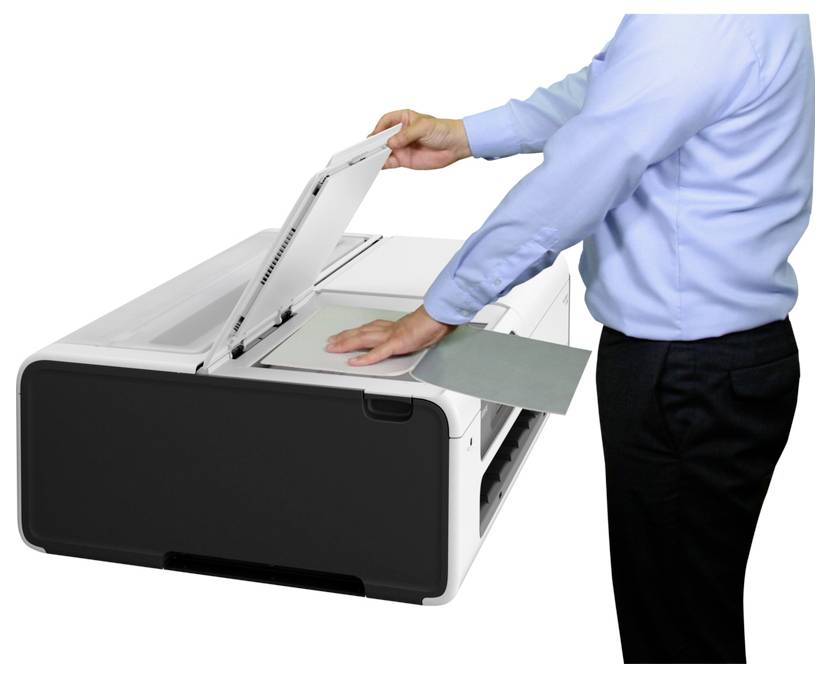 Person, die ein Dokument auf einen Flachbettscanner/Kopierer legt, um es zu scannen oder zu kopieren.