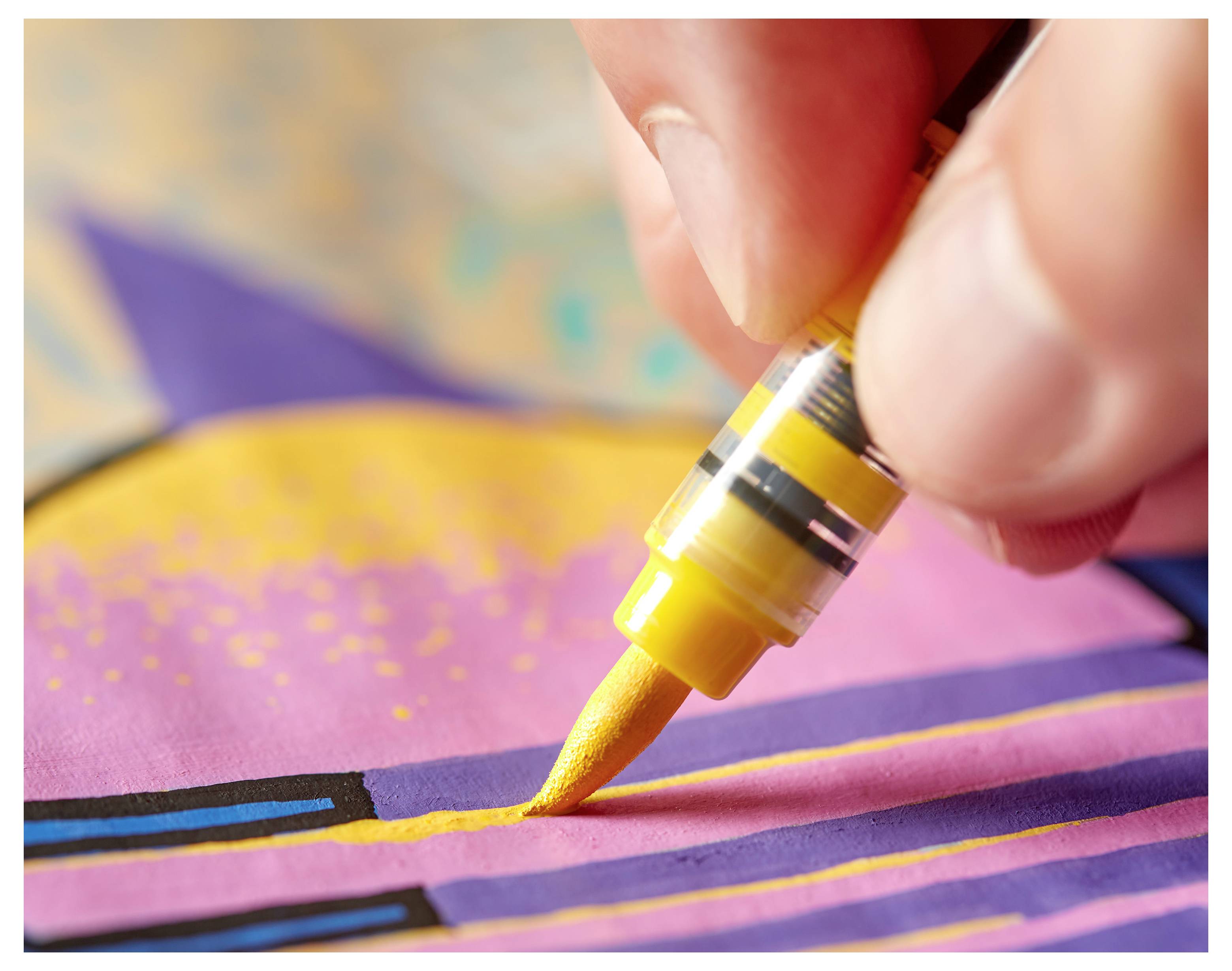 Hand, die mit einem gelben Farbmarker eine Linie auf einem farbenfrohen abstrakten Kunstwerk zeichnet, Nahaufnahme.