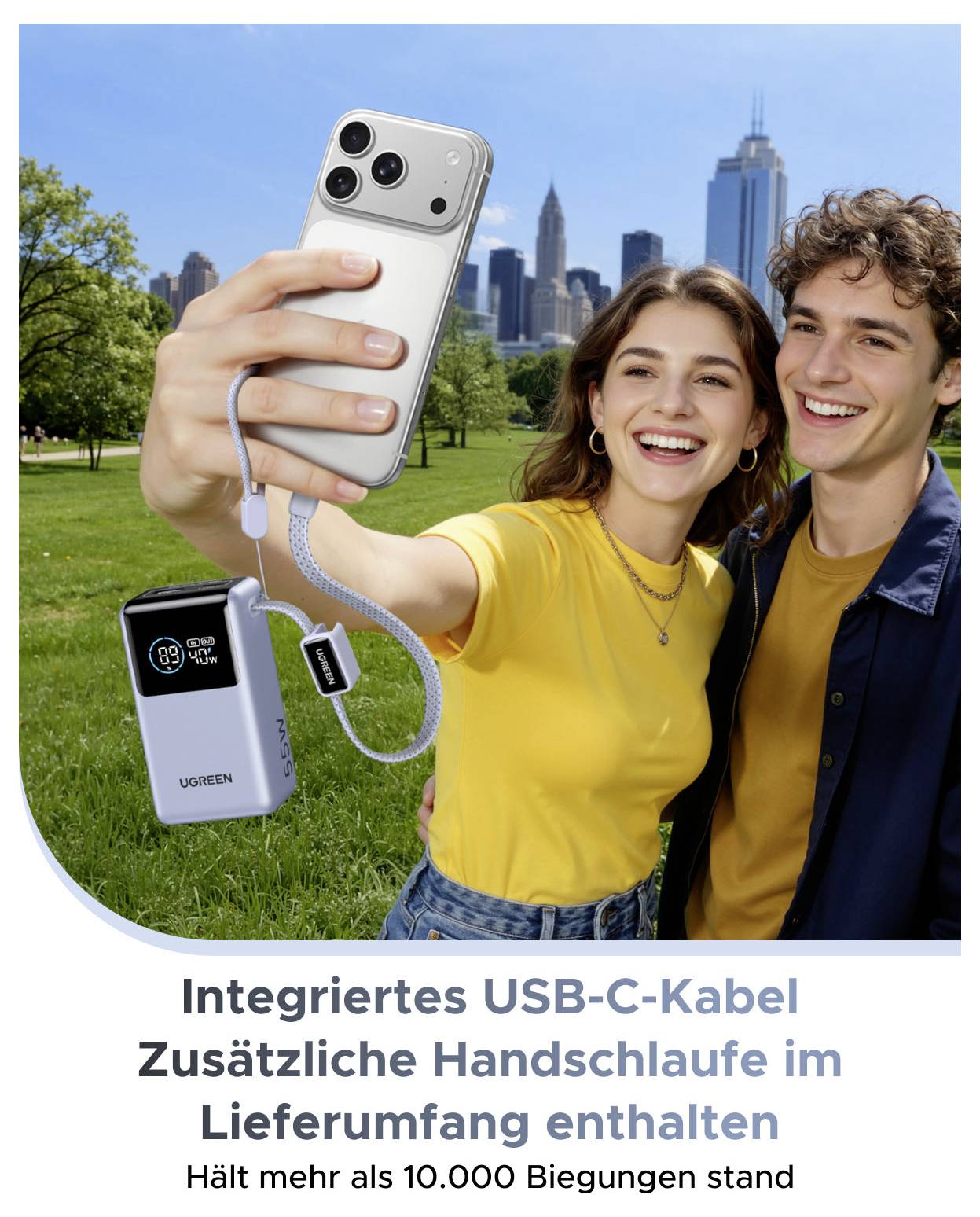 Junges Paar, das im Park ein Selfie mit einer tragbaren Powerbank und integriertem USB-C-Kabel macht; deutscher Text besagt, dass ein zusätzliches Handgelenksband enthalten ist und über 10.000 Biegungen standhält.