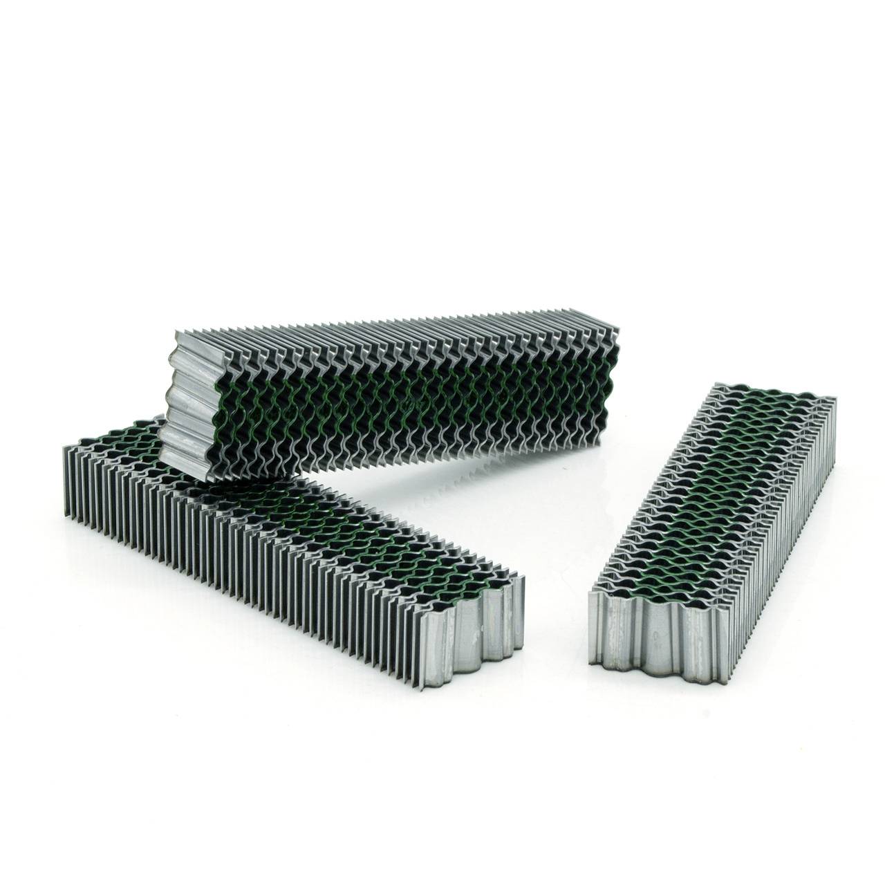 Drei gewellte Metallgitterfiltermatten auf weißem Hintergrund angeordnet, dargestellt als industrielles Filtrationsmaterial.