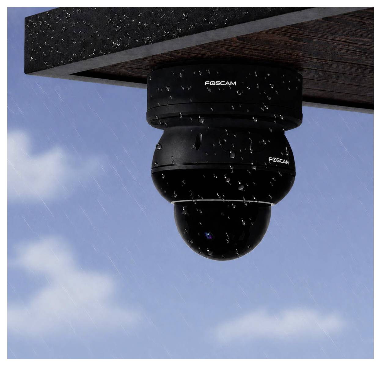 Schwarze Foscam-Überwachungskamera unter einem Dachvorsprung montiert, vor einem regnerischen blauen Himmel fotografiert.