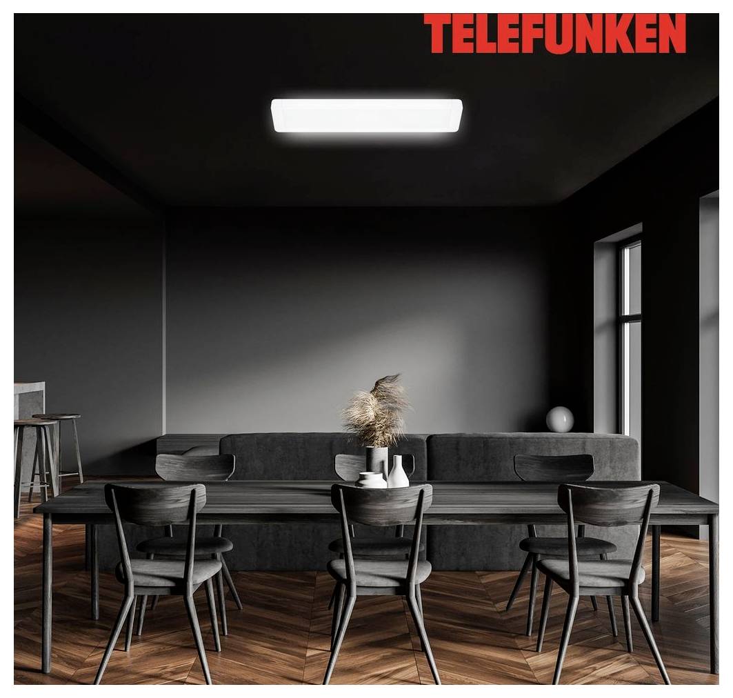 Dunkles modernes Esszimmer mit TELEFUNKEN-Logo, mit langem Tisch, sechs Stühlen, grauem Sofa, Pendelleuchte und Holzfischgrät-Parkettboden.