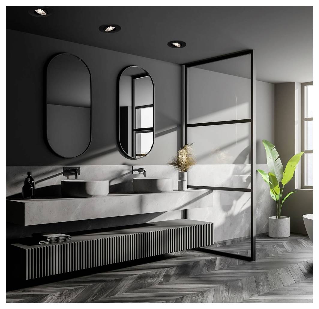Modernes graues Badezimmer mit Doppelwaschbecken, runden Spiegeln, Glasduschwand und einer Topfpflanze neben einem sonnendurchfluteten Fenster.