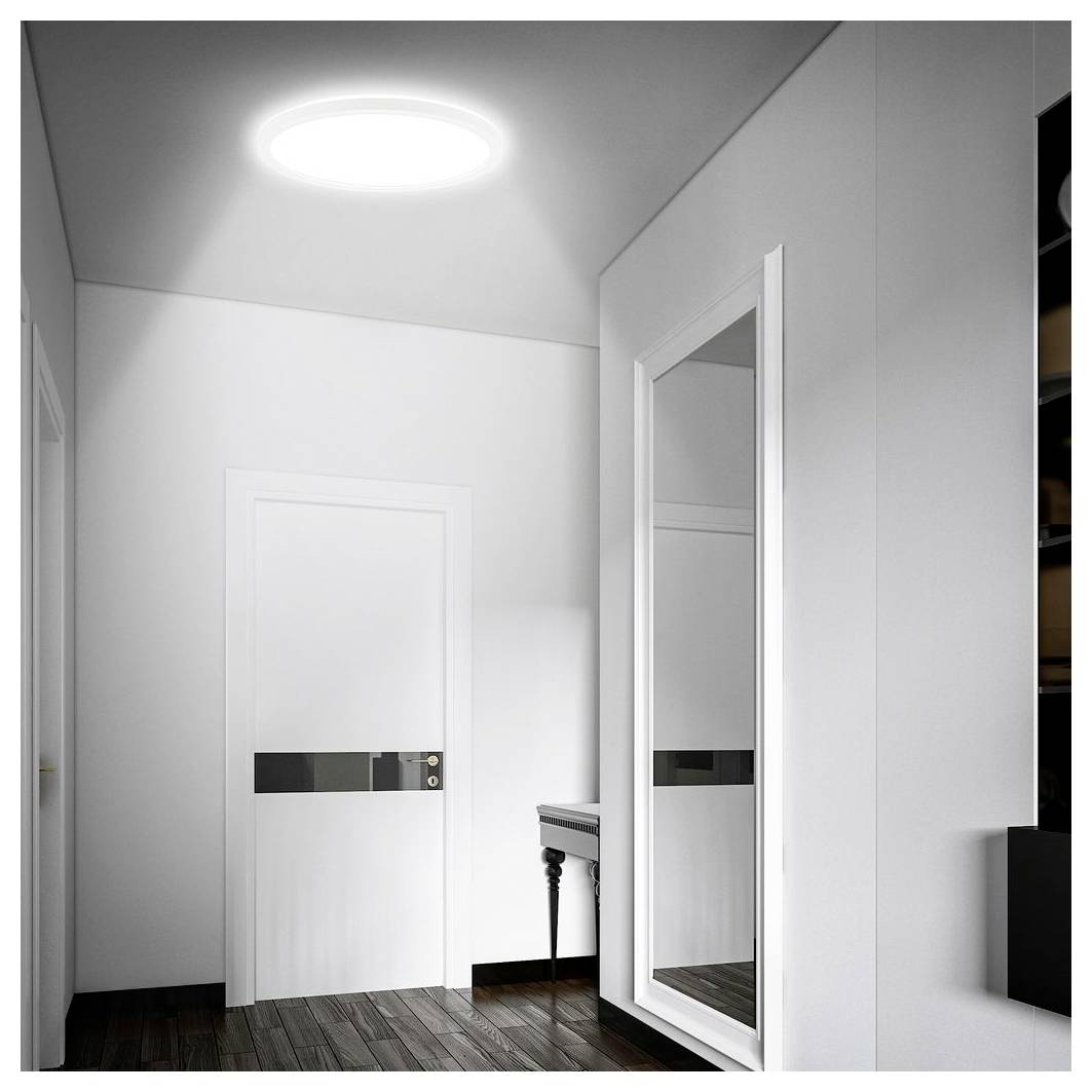 Moderner weißer Flur mit geschlossener Tür, großem Wandspiegel, kleinem Tisch und Deckenleuchte auf dunklem Holzboden.