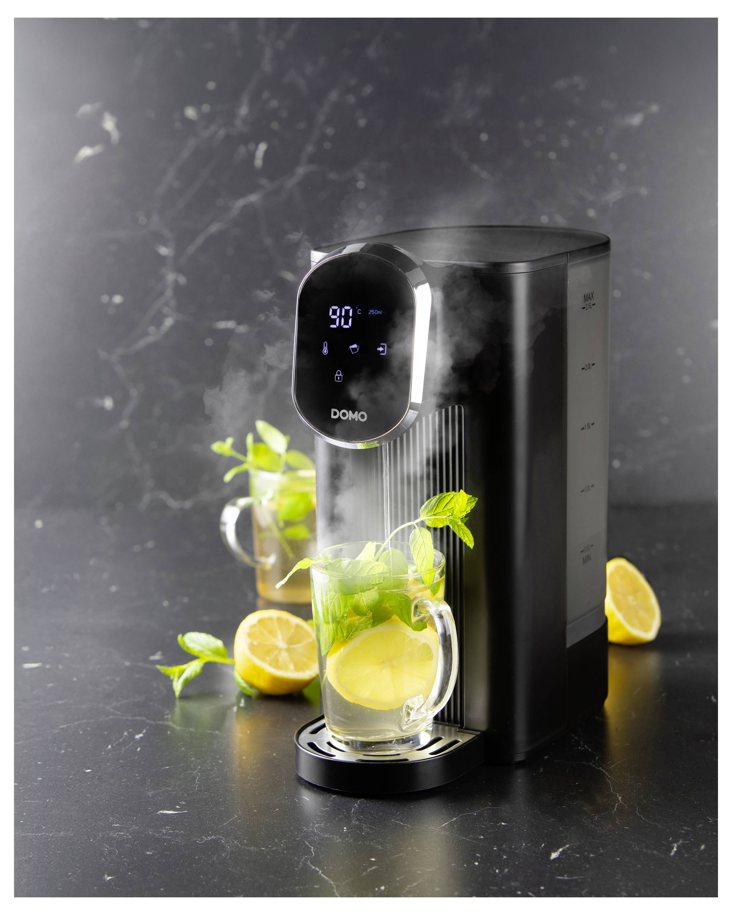 Schwarzer Heißwasserbereiter mit digitaler Anzeige, der Wasser in einen Glaskrug mit Zitronenscheiben und Minze ausgibt.