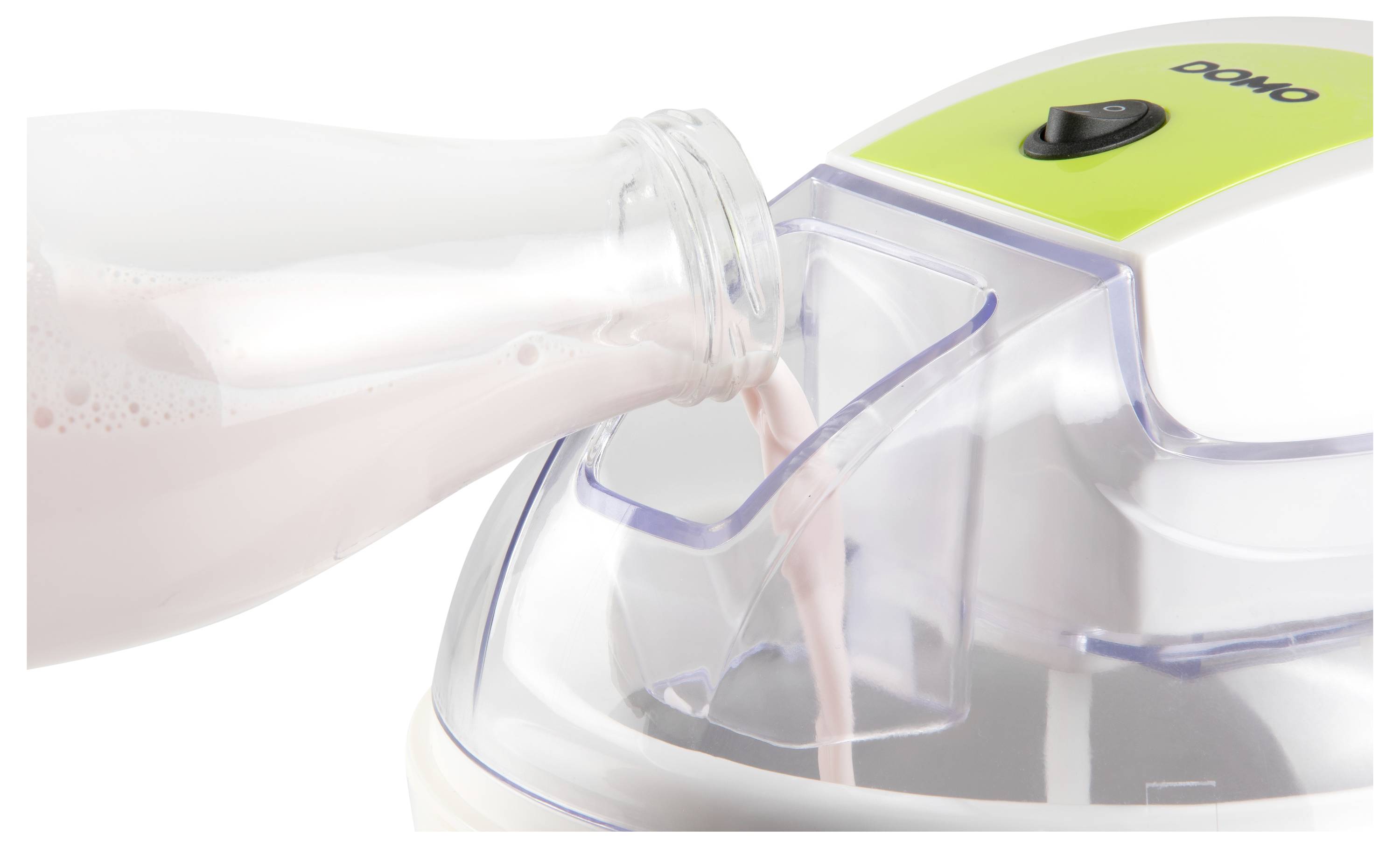 Milch wird aus einer Flasche in einen Pulvermischer mit einem durchsichtigen Krug und grünem 