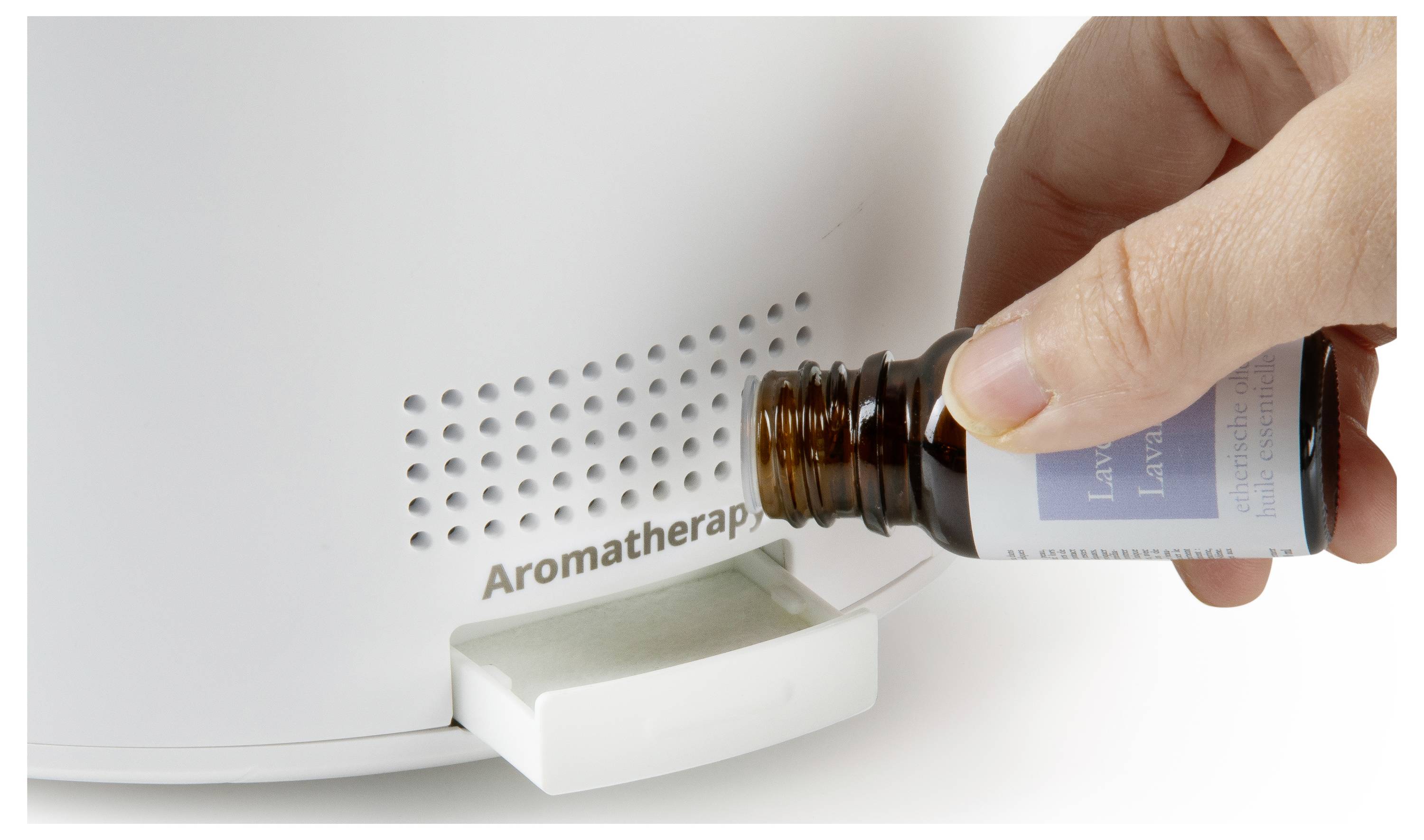 Hand fügt Aromatherapieöl durch die Nachfüllöffnung in einen Diffuser ein.