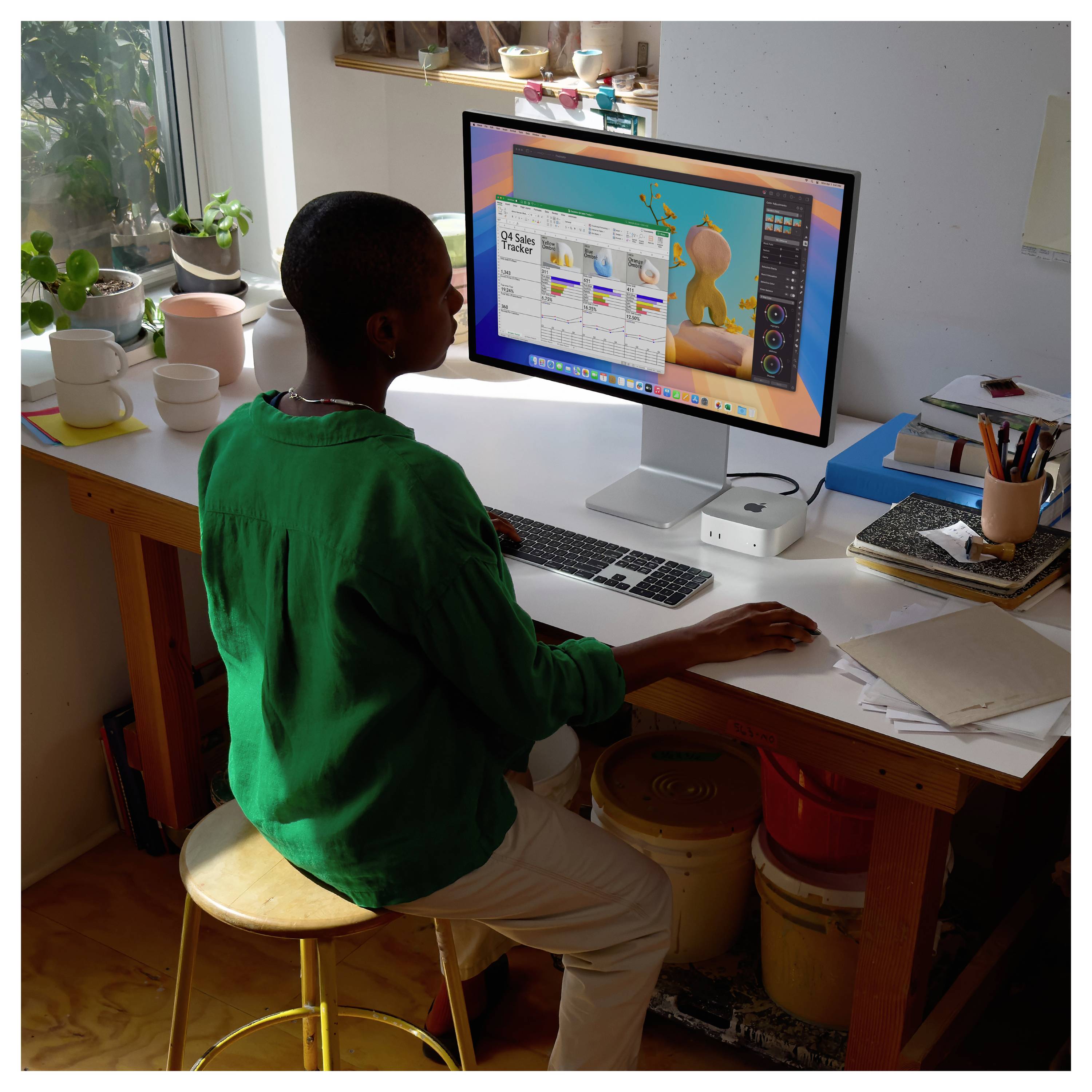 Eine Person, die an einem Schreibtisch an einem Desktop-Computer arbeitet, mit einem Gestaltungs- oder Bearbeitungsprogramm, das auf dem Bildschirm geöffnet ist.