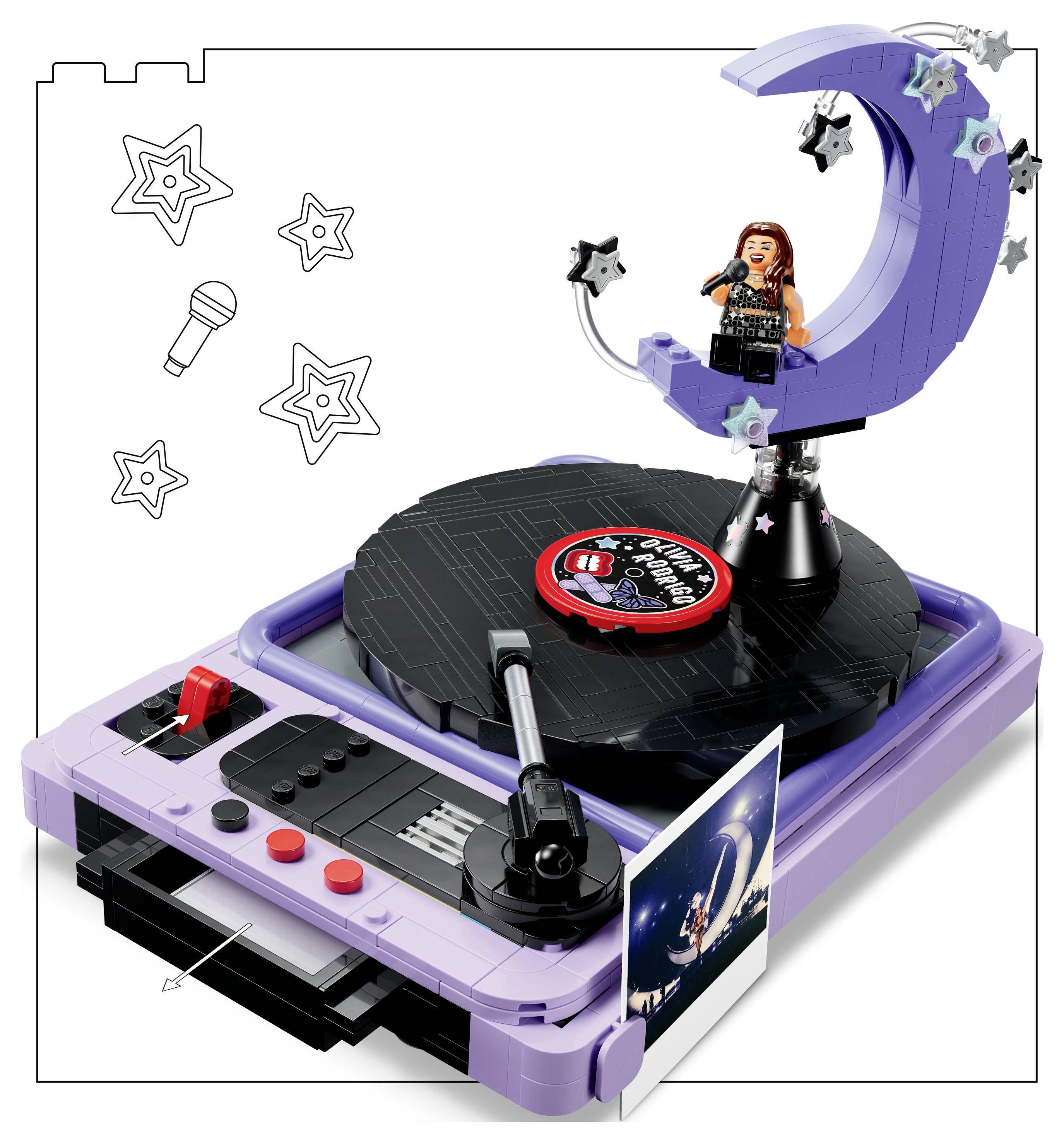 Spielzeug-Karaoke-Plattenspieler-Set mit einem violetten Plattenspieler, drehendem Schallplattenteller, Mikrofon und einer Sängerfigur auf einer sichelförmigen Mondbühne mit Sterndekoration.