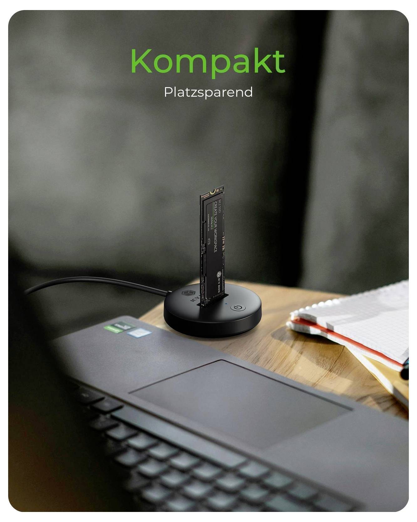 Kompakte, platzsparende Laptop-Dockingstation mit vertikalem SSD auf rundem Sockel neben einem Laptop; der Text lautet „Kompakt