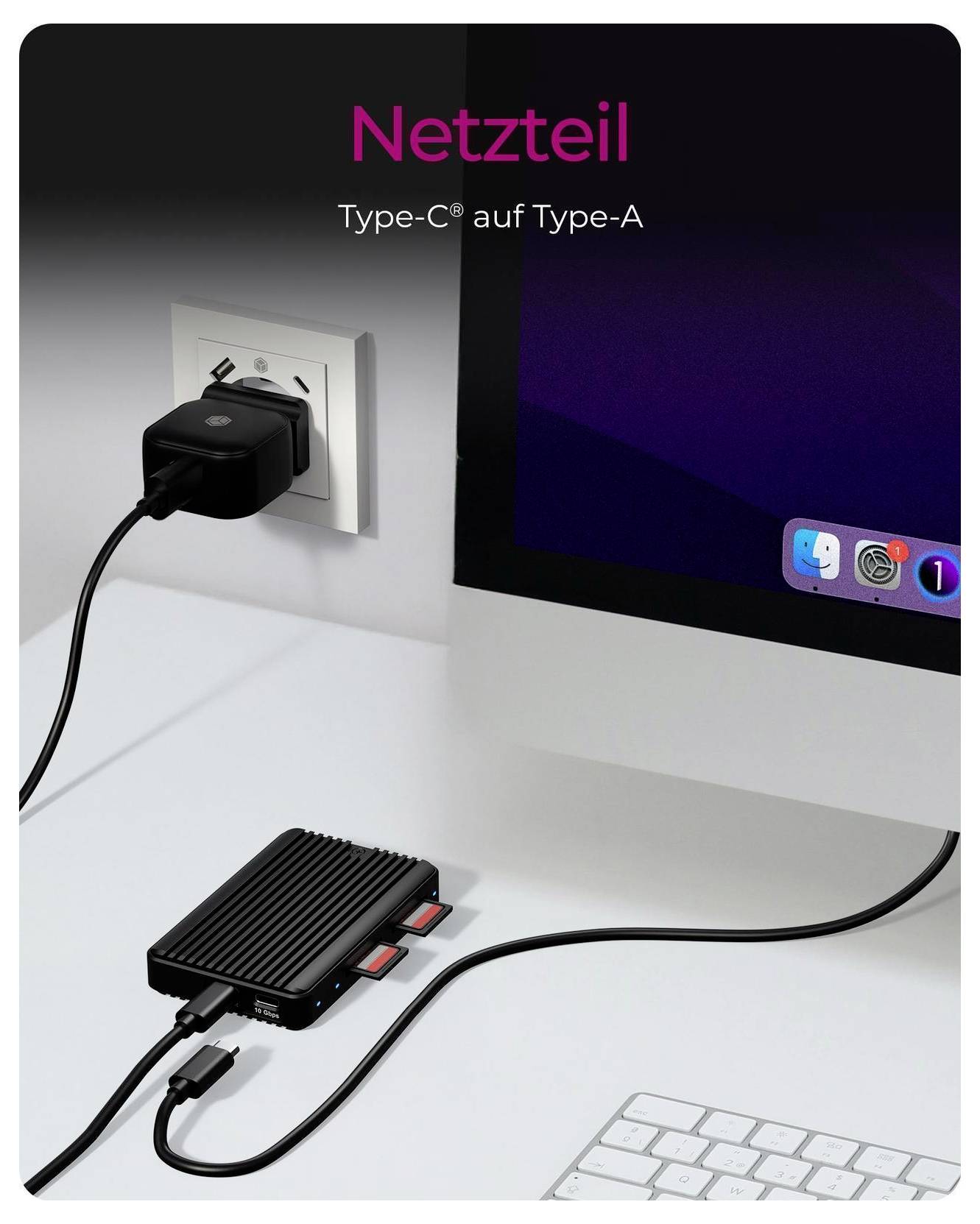 Kompakter schwarzer Stromadapter auf einem Schreibtisch, angeschlossen an eine Wandsteckdose und über ein USB-Typ-C-auf-Typ-A-Kabel mit einem Computer verbunden; Text lautet „Netzteil