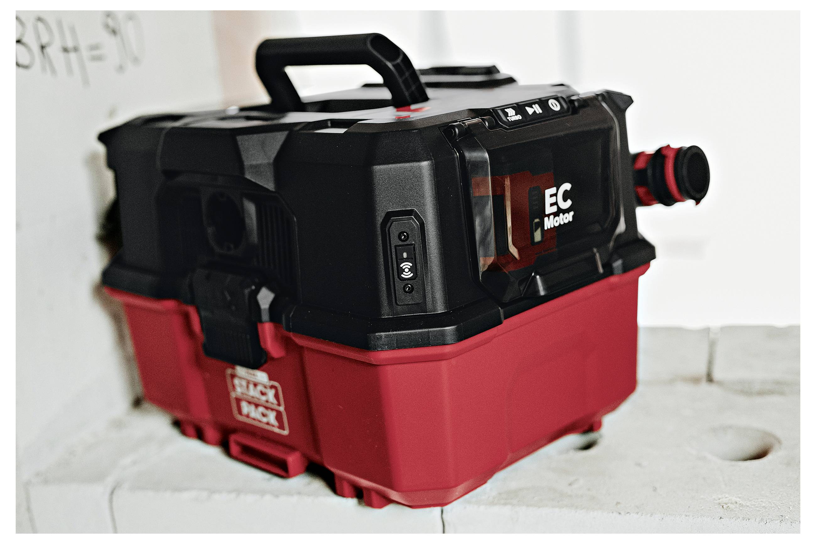Ein kabelloses Werkstattstaubsauger mit schwarzem Deckel und rotem Tank, beschriftet mit „EC Motor