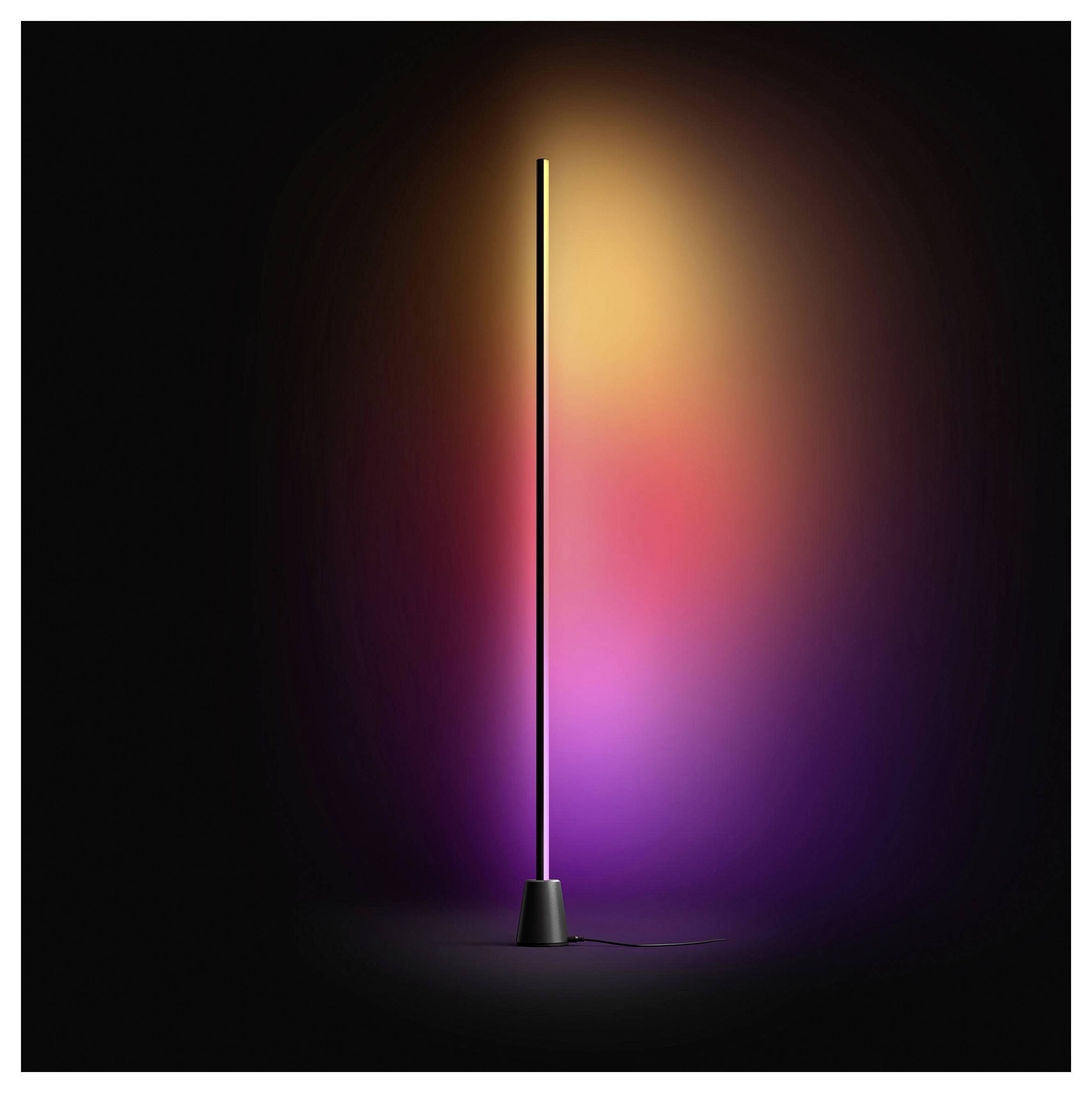Eine schlanke schwarze Stehleuchte mit einem leuchtenden vertikalen LED-Streifen, der einen warmen orange, rosa und violetten Farbverlauf gegen einen dunklen Hintergrund wirft.