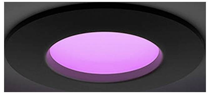 Nahaufnahme einer schwarzen eingelassenen Deckenleuchte mit einem leuchtenden rosa-violetten Zentrum.