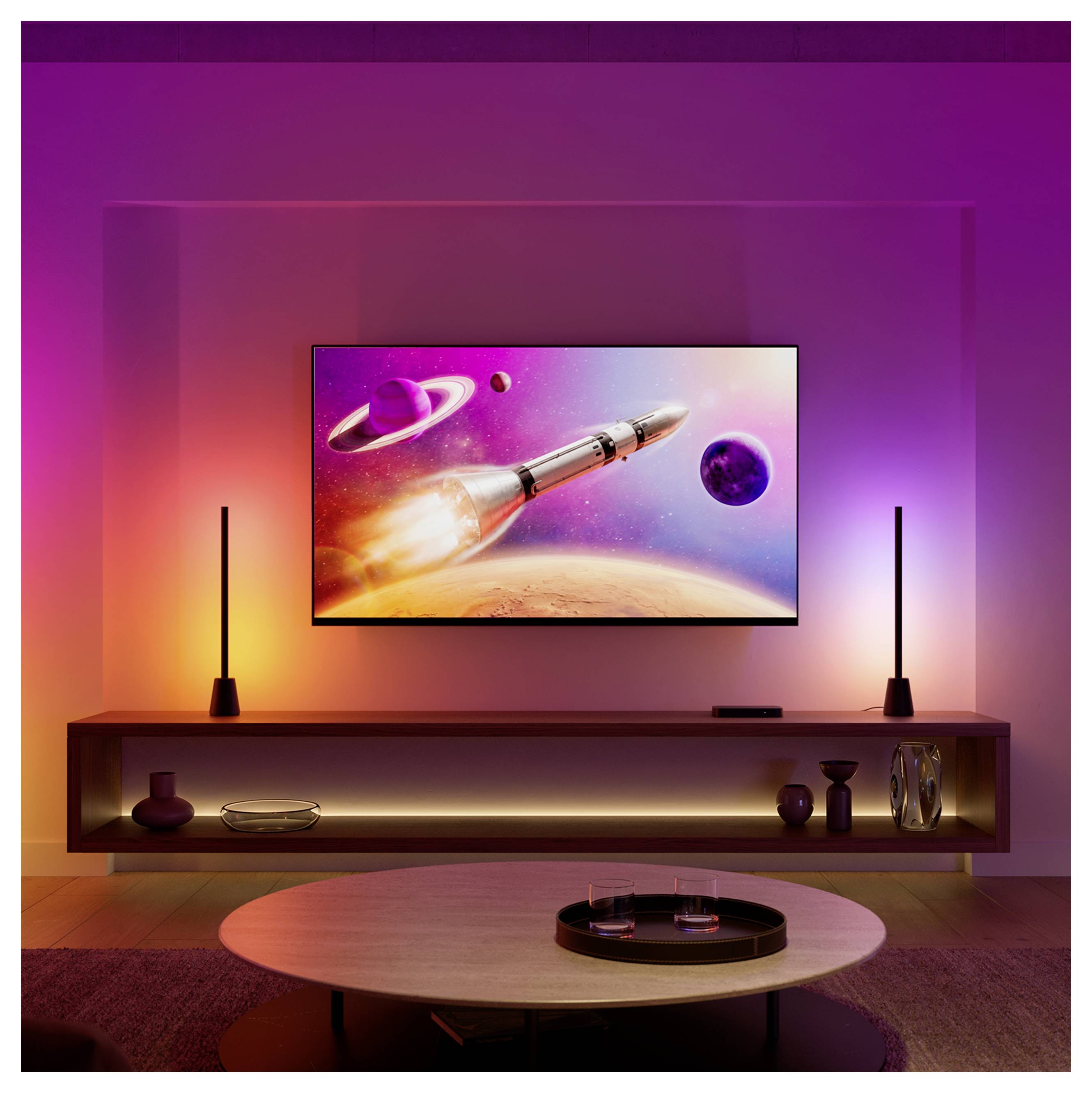 Modernes Wohnzimmer mit an der Wand montiertem Fernseher, der eine Rakete im Weltall zeigt, flankiert von zwei schlanken Leuchten, mit einem niedrigen Konsolenregal und rundem Couchtisch, beleuchtet durch lila-oranges Umgebungslicht.
