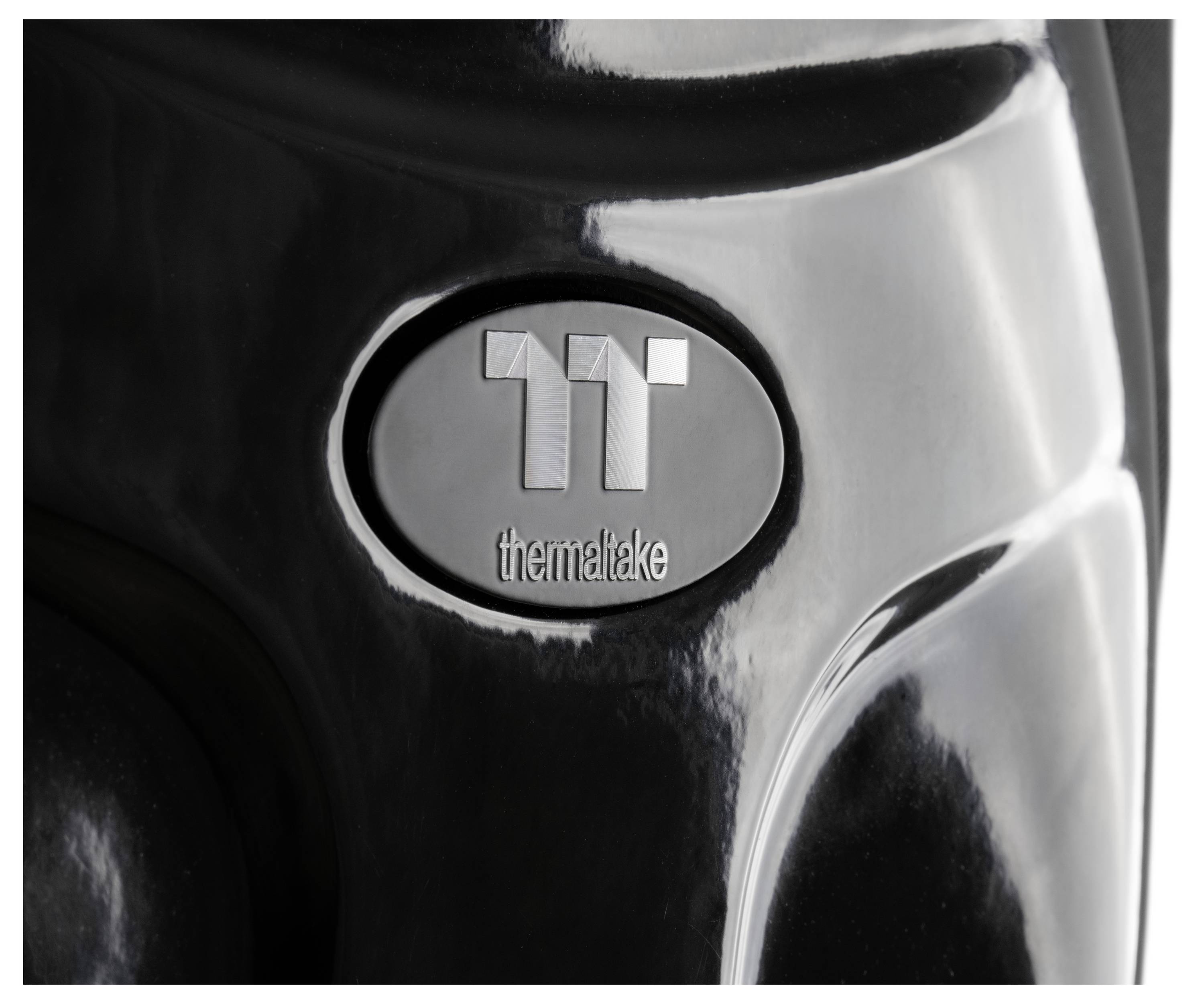 Nahaufnahme eines glänzend schwarzen Thermaltake-Computergehäuses oder Kühlers mit dem zentriert angebrachten Thermaltake-Logo.
